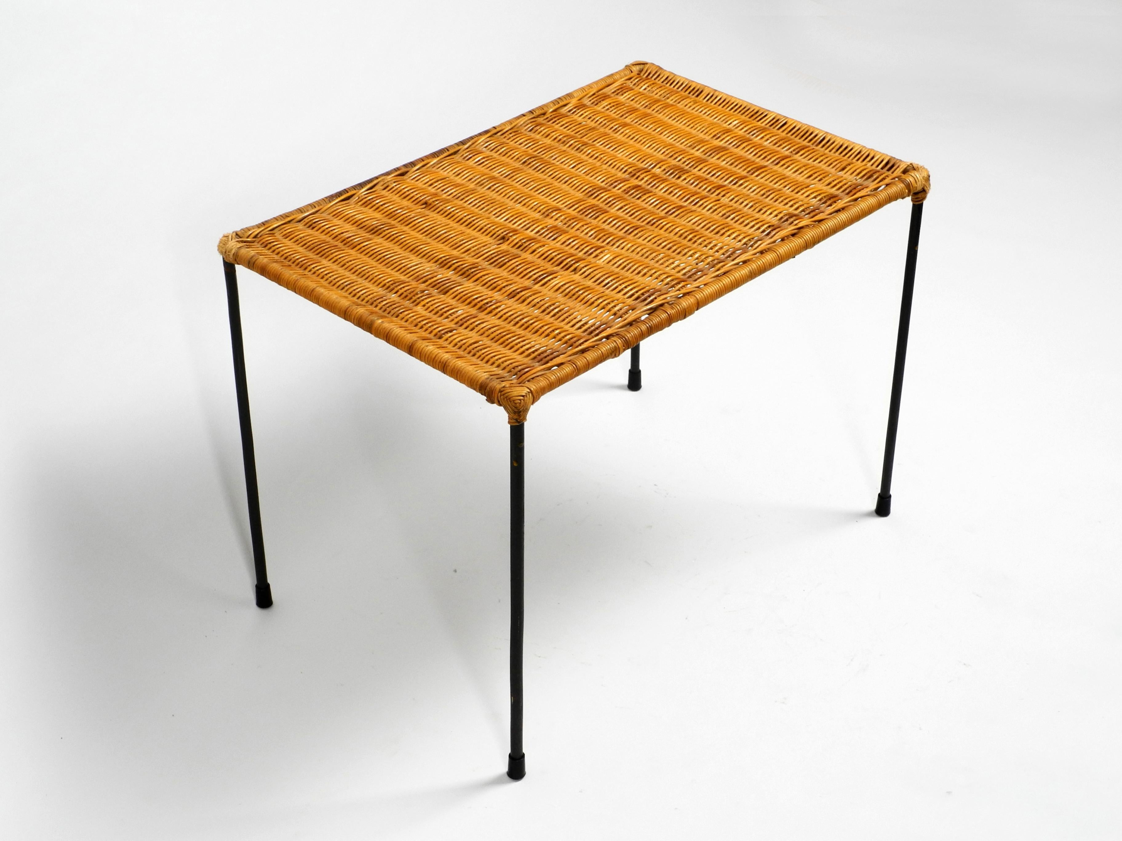 Beautiful Mid-Century Modern side table made of rattan with a iron frame. 
The frame and feet are made entirely of black painted iron.
Very high quality minimalist 1950s string design. Probably from an italian production.
In a very good vintage
