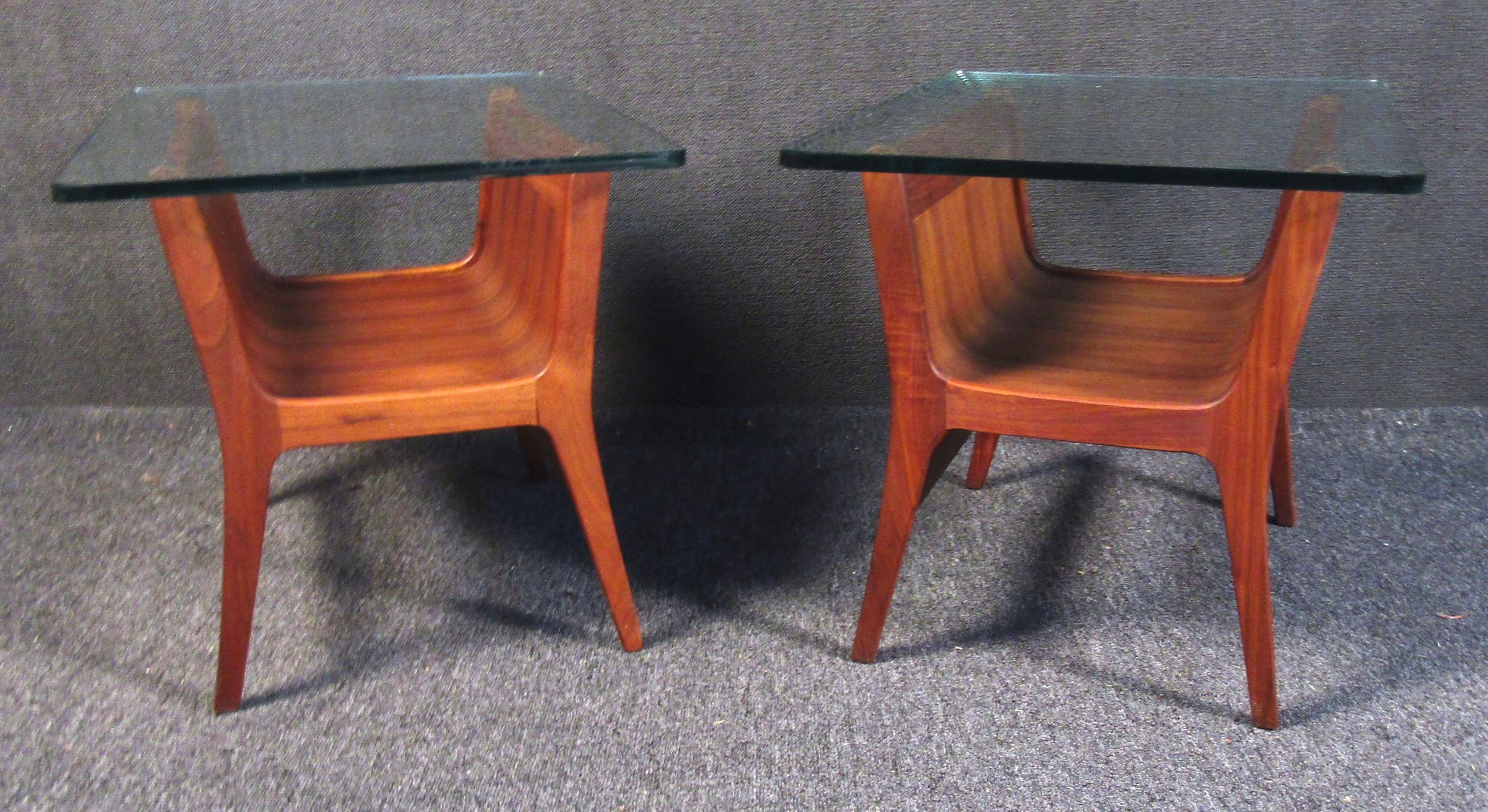 Set of two vintage modern side tables. These tables feature curving sculptural boomerang shaped wood legs with chic and sturdy thick glass tops, each table has a sizable lower shelf with sculptural curved corners to match the legs.

Please confirm