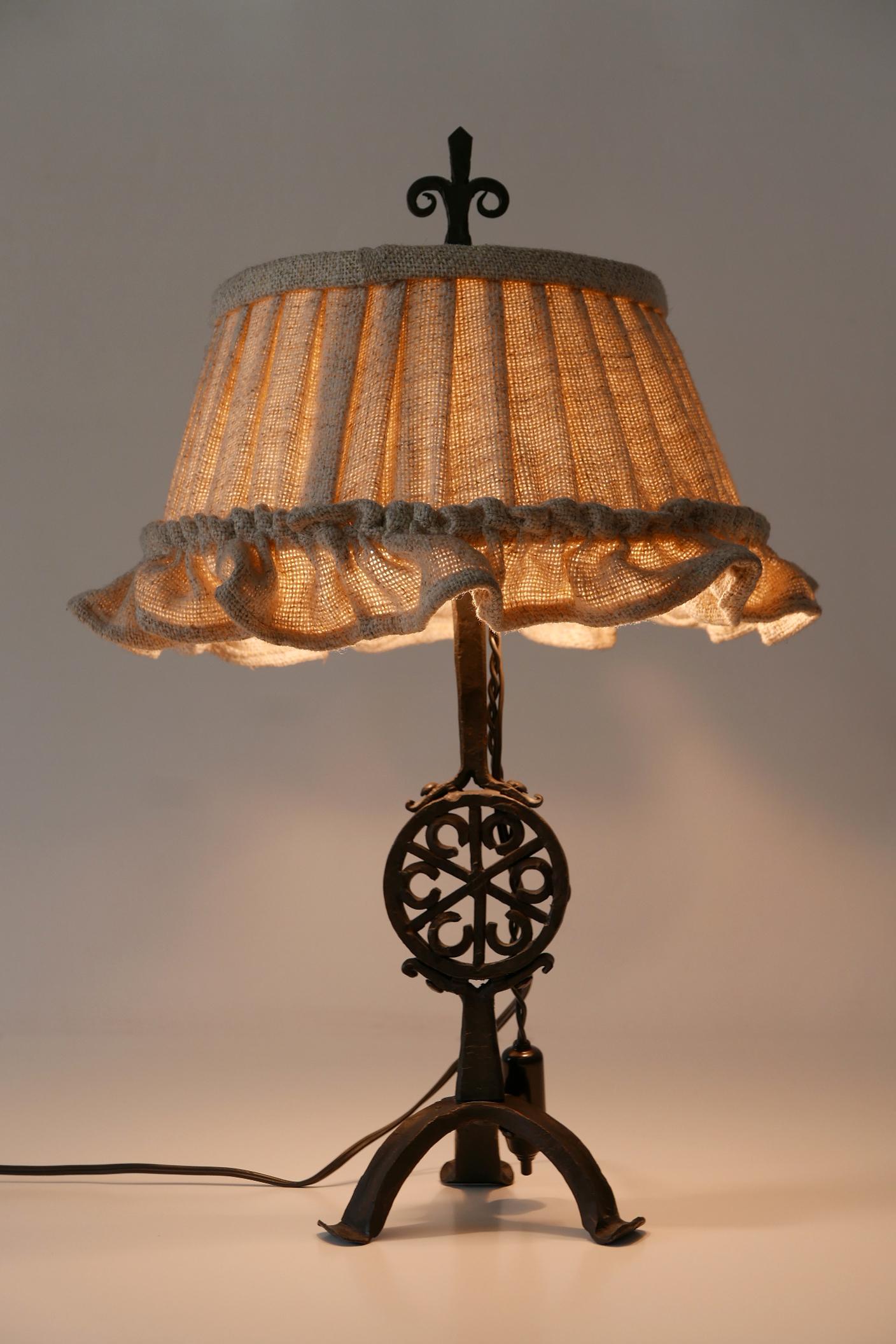 Elegant Mid-Century Modern night table lamp. Manufactured in Germany, 1960s.

Executed in wrought iron and jute, the night table lamp comes with 2 x E27 / E26 Edison screw fit bulb holders, is wired, in working condition and runs both on 110 / 230