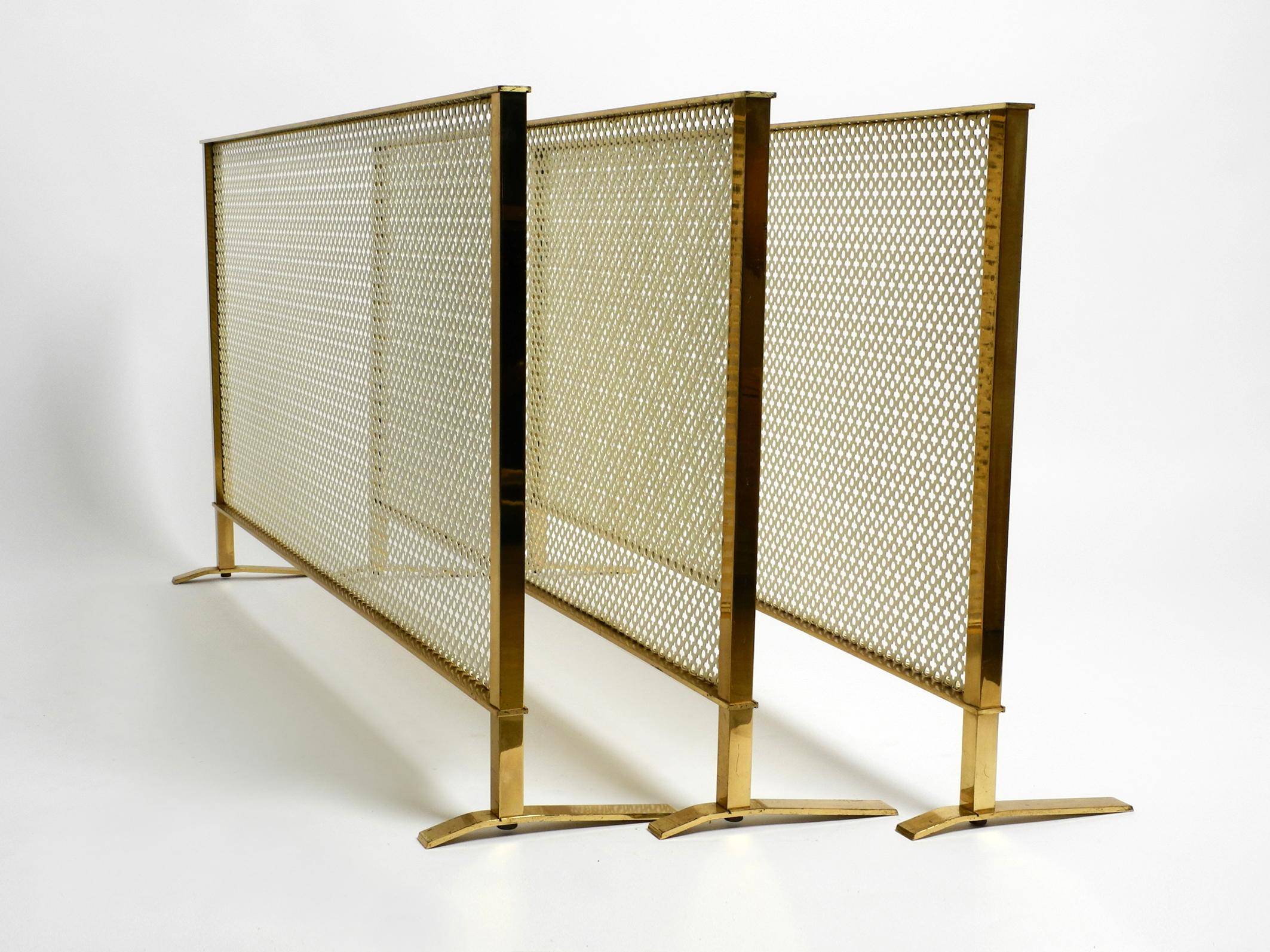 Beautiful mid century radiator covering or fireplace screen made of brass 
and perforated sheet metal by Vereinigte Werkstätten.
Great, very elegant design. Made in Germany.
Frame and feet are made of shiny brass, cover in the middle is made of