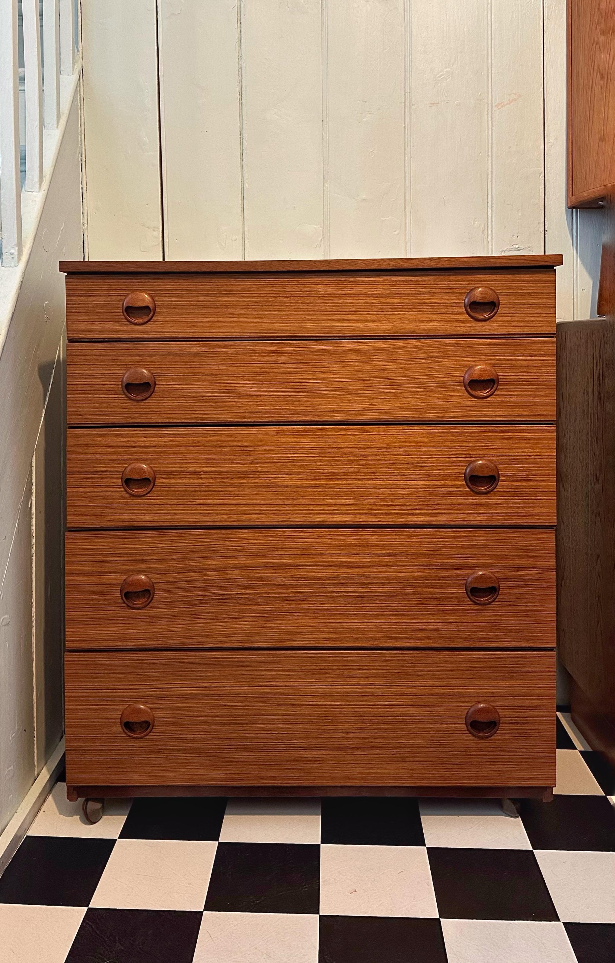 Beautiful Mid Century teak chest of drawers by Schreiber. It offers plenty of storage with five spacious drawers. 

Stunning design with beautiful teak grain throughout and stylish carved handles. 
In very good vintage condition with very some minor