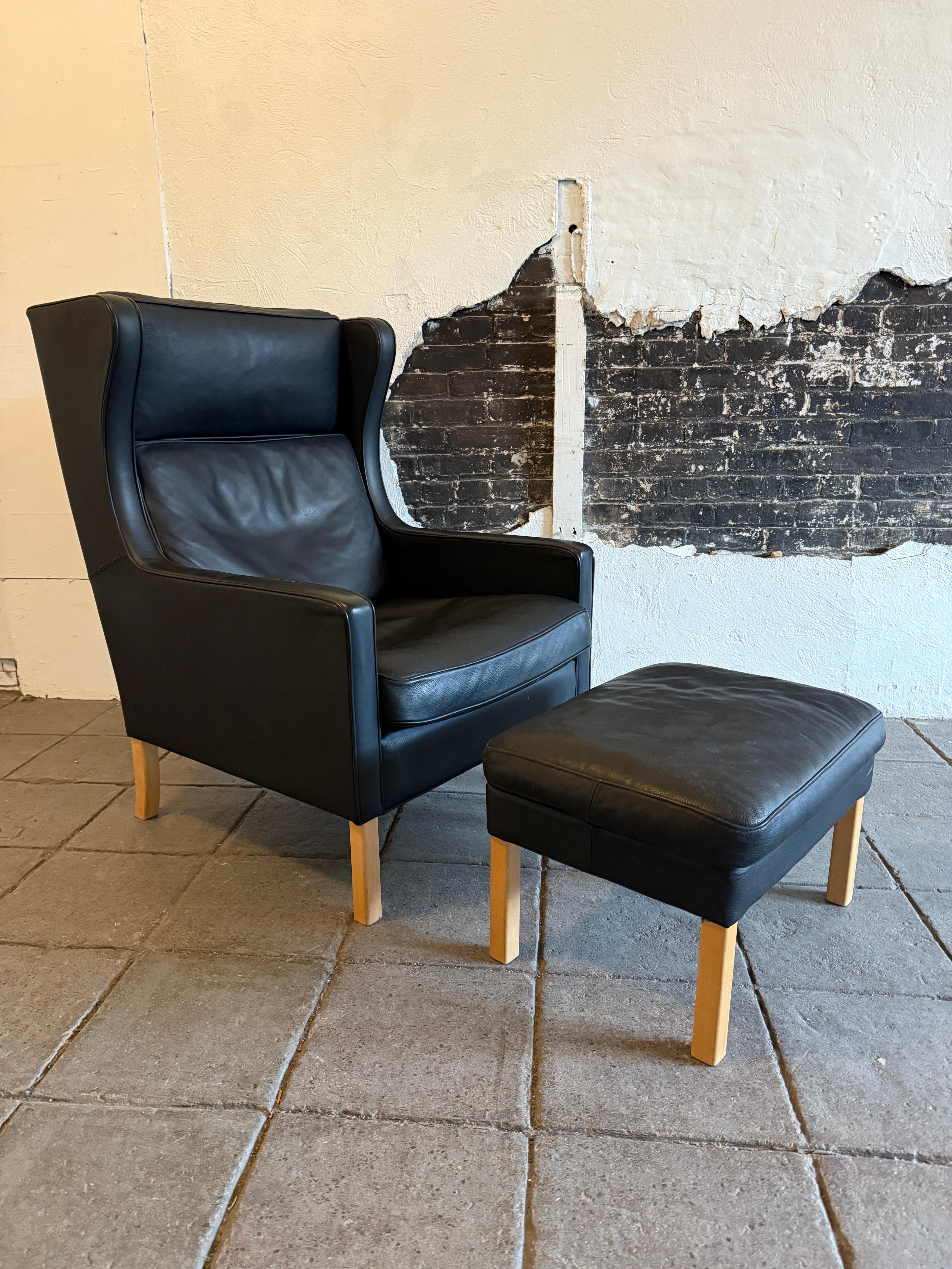 Beautiful Mid Century Scandinavian modern Black Leather Wingback Chair and Ottoman in the style of Børge Mogensen. Very clean chair with light beech wood legs and soft black leather. Very comfortable chair great for your beach house or House in the