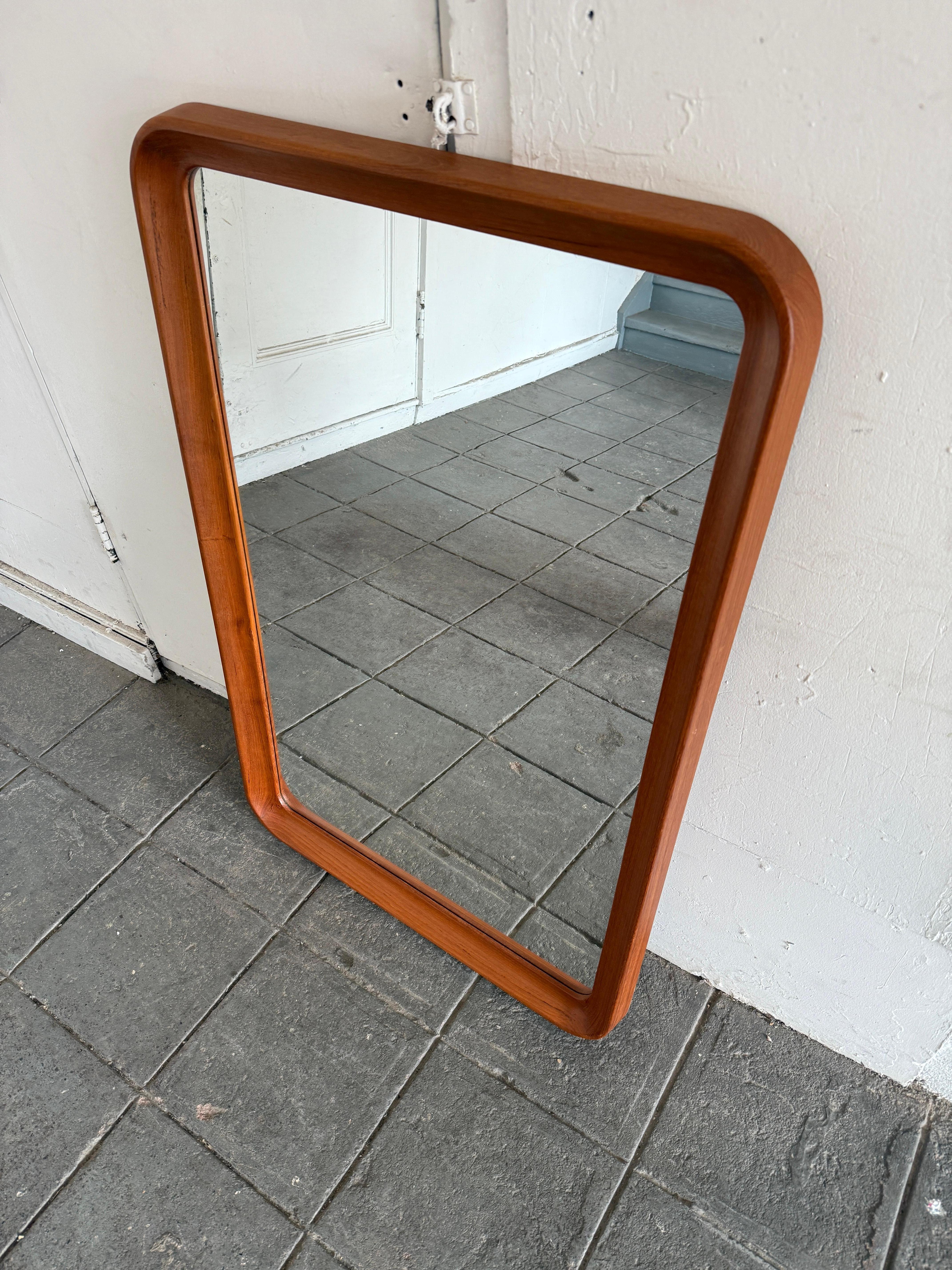 Specchio da parete scolpito in stile danese moderno di metà secolo. Bellissimo specchio in teak massiccio e vetro con lavorazione di alta qualità. Angoli e dettagli curvi. Label -  Progettato. Prodotto in Danimarca. Molto pulito - pronto all'uso.