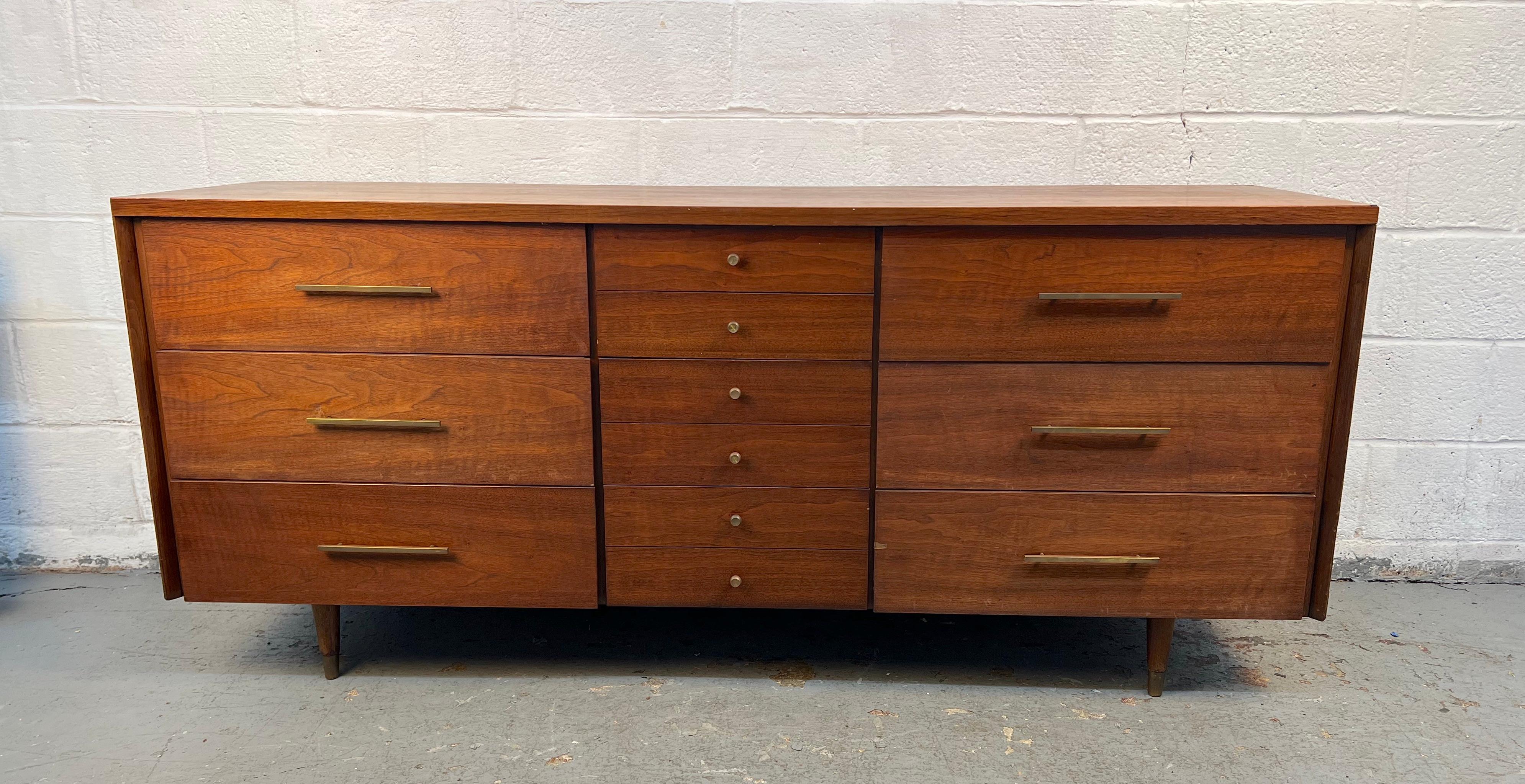 Un elegante comò in noce di John Stuart, esemplificativo del design moderno di metà secolo. Le linee pulite, le ricche venature del legno e le proporzioni raffinate mettono in risalto l'artigianato, mentre i cassetti multipli offrono un ampio spazio