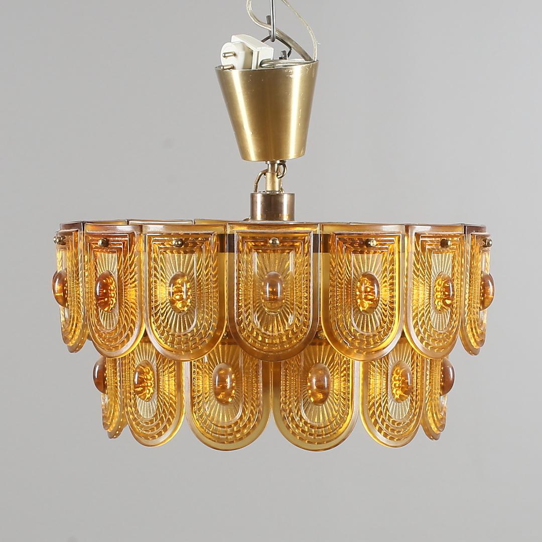 Brass construction with pressed orange glass elements. Made in Sweden the 1960s.
 