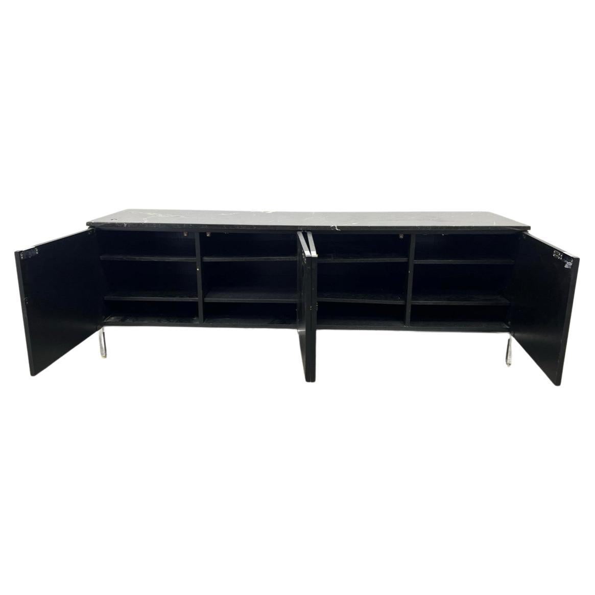 Beautiful and sophisticated Florence Knoll low credenza in black lacquer and a Nero Marquina Shiny Marble Top. Featuring (4) cabinet doors with adjustable shelves on a chrome base with chrome pulls. Sleek and ready for use for your home or office as