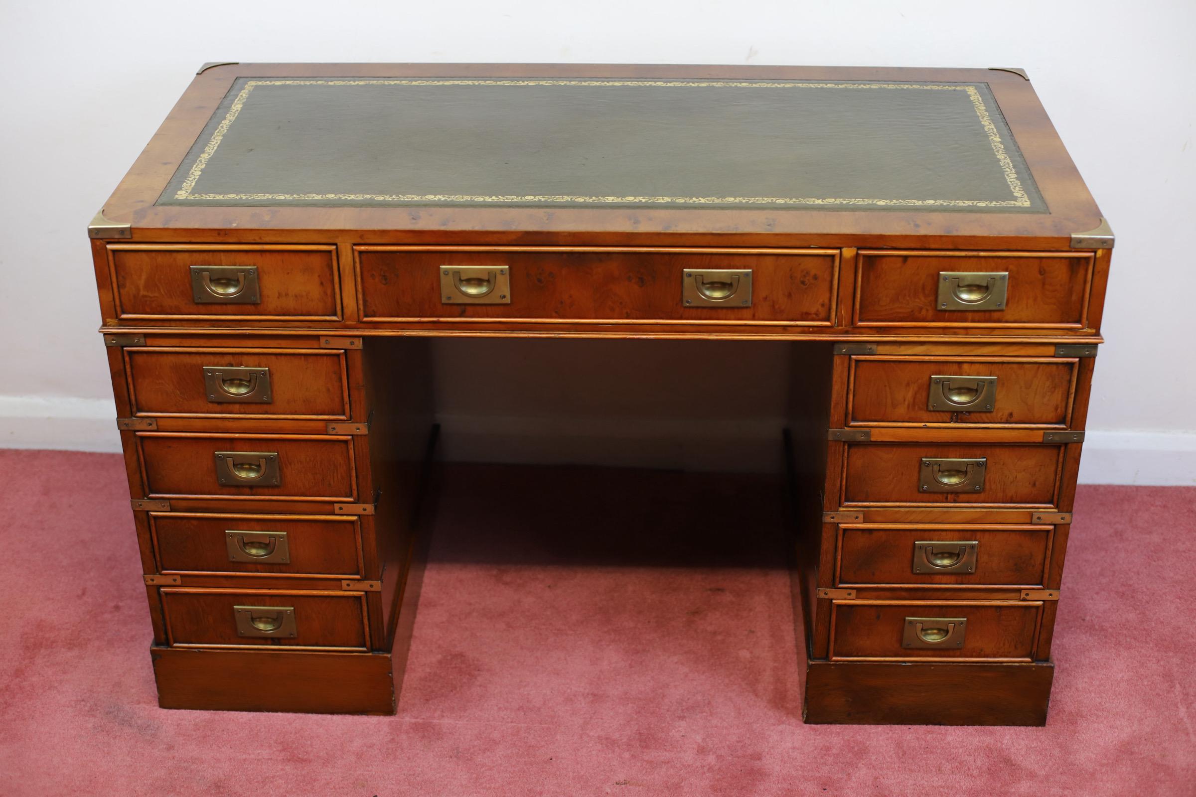 We delight to offer for sale this lovely yew wood military campaign style twin pedestal desk, rectangular top with inset leather , fitted with eleven drawers, brass brackets and recessed brass handles, on bracket feet. In good condition . We may