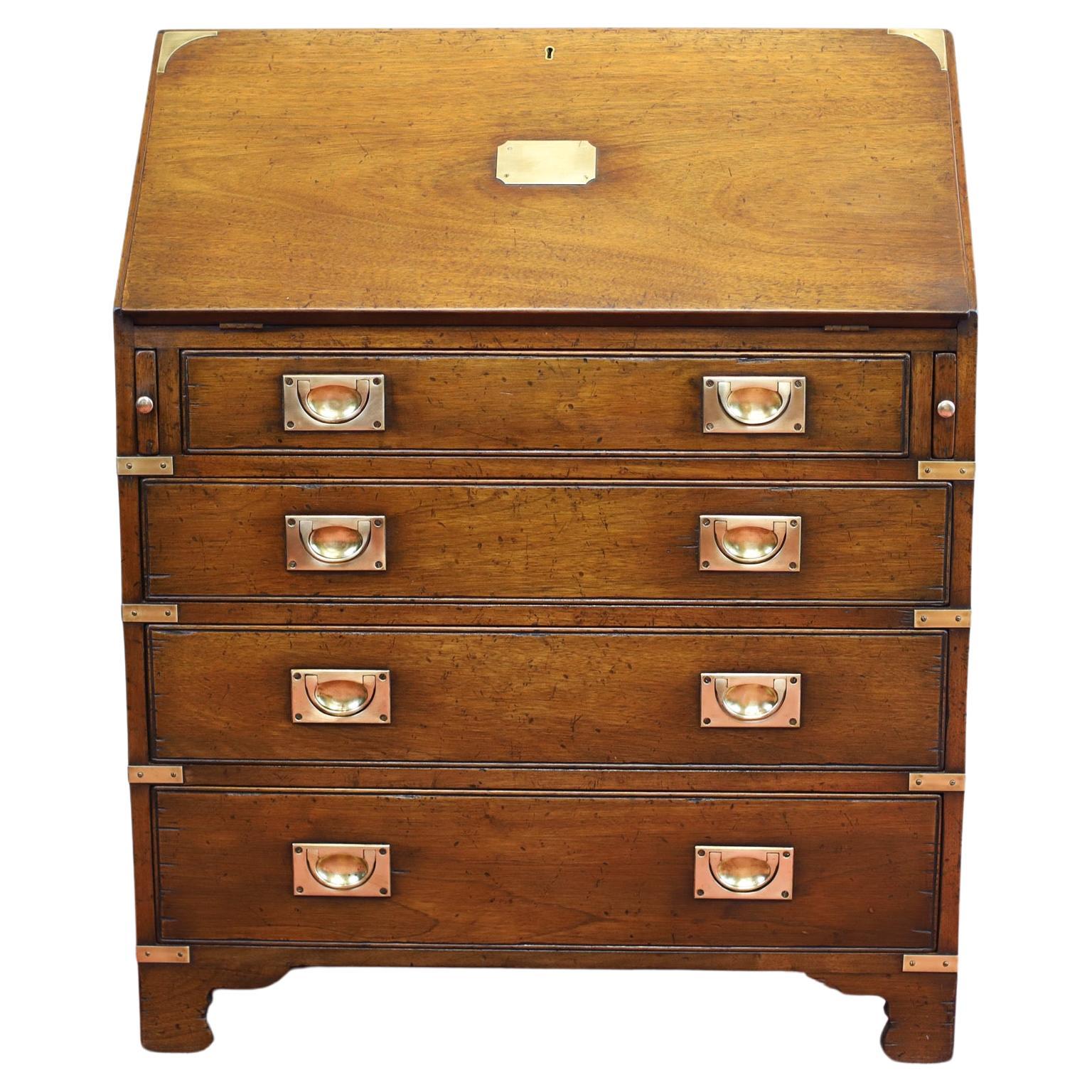 This beautiful writing bureau desk is a stunning example of military campaign furniture retail . Crafted from sturdy oak and adorned with brass accents, this antique desk features five spacious drawers and a leather writing surface. The rich brown