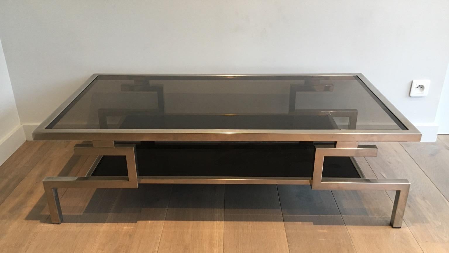 This beautiful modernist coffee table is made of chrome with smoked glass shelves. The design is very interesting. This cocktail table is a French work, circa 1970.