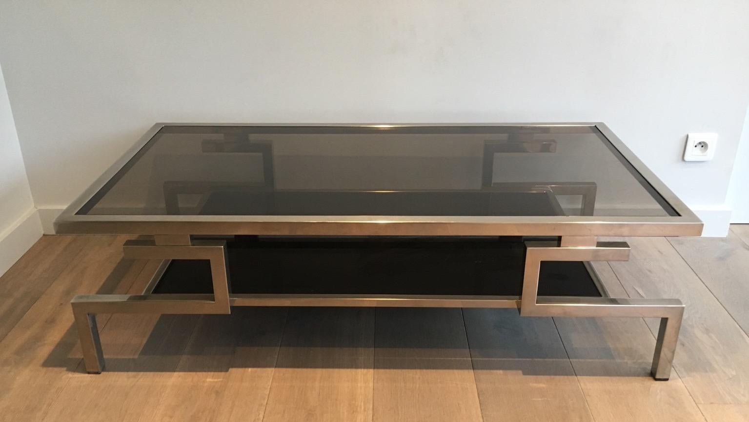 Cette magnifique table basse moderniste est fabriquée en chrome avec des étagères en verre fumé. Le design est très intéressant. Cette table de cocktail est une œuvre française, vers 1970.