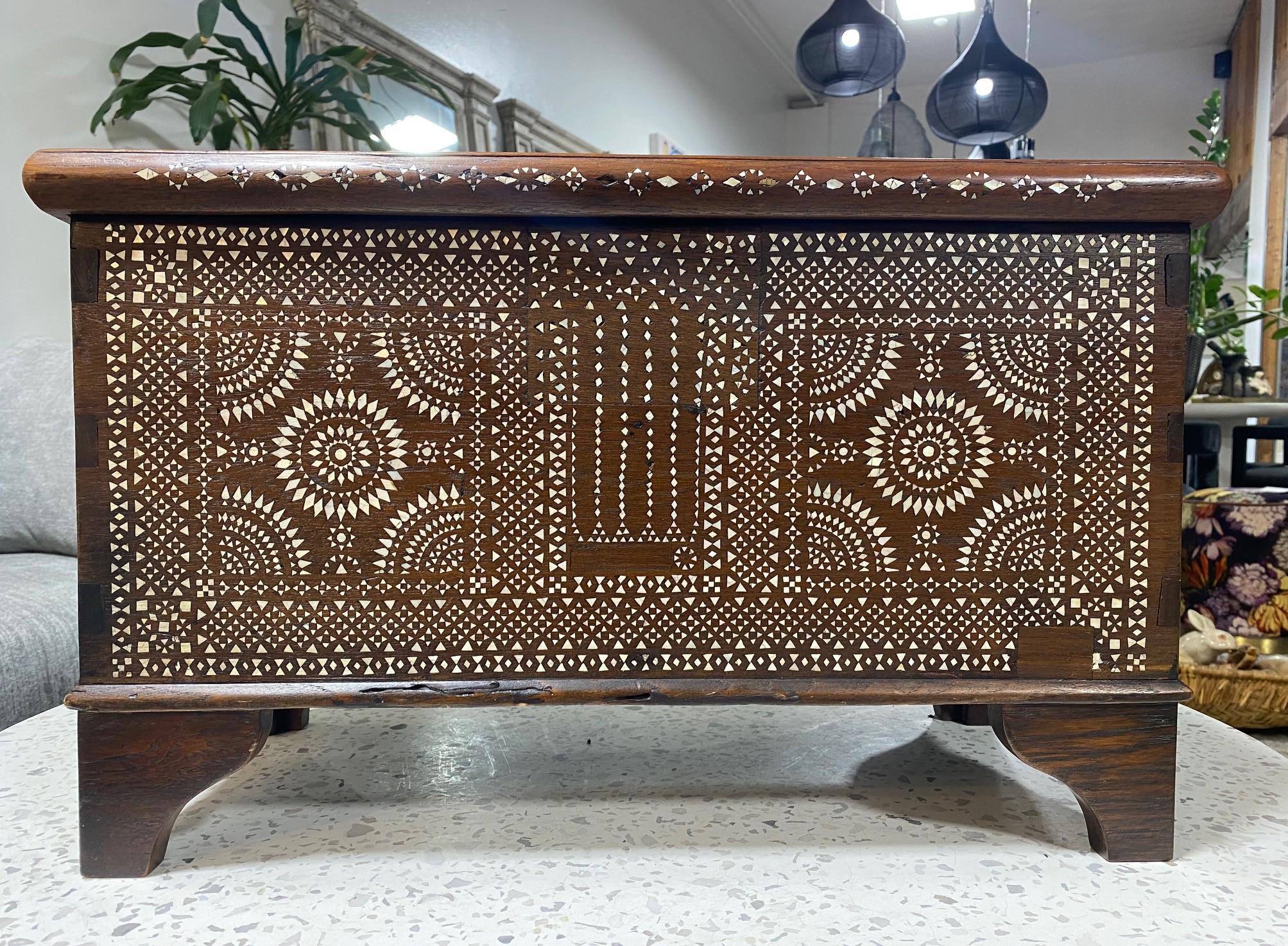 Stunning mosaic, geometric design, and gorgeous craftsmanship. This work is made of beautiful dark wood and shell and/or bone inlay. The iron handles are also a nice touch. A genuine work of art.

A very eye-catching and unique piece. Would clearly