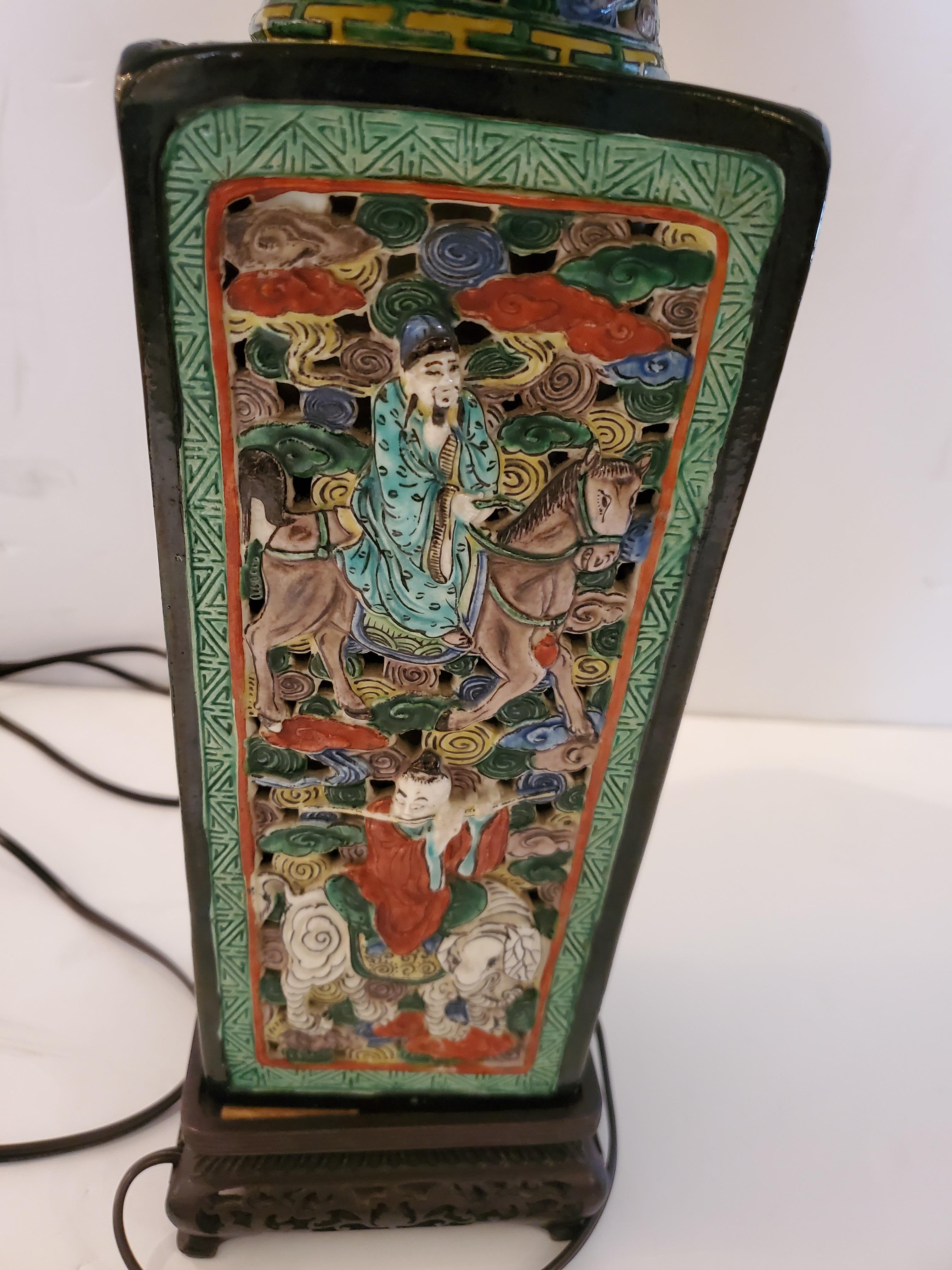 A rare vintage Asian table lamp having impressively detailed ceramic base decorated with figures and dense background in red, green, blue and black. Original silk black shade is included.
Base 5