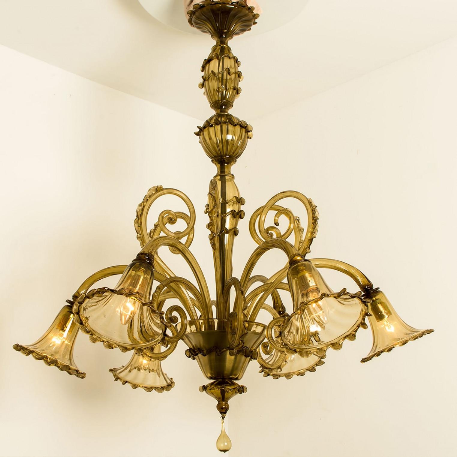 Beautiful and elegant hand blown Murano glass chandelier. Made around the 1970s. This light fixture consists of six hand blown Murano glass arms. The brown smoked glass refracts the light beautifully.                                                 