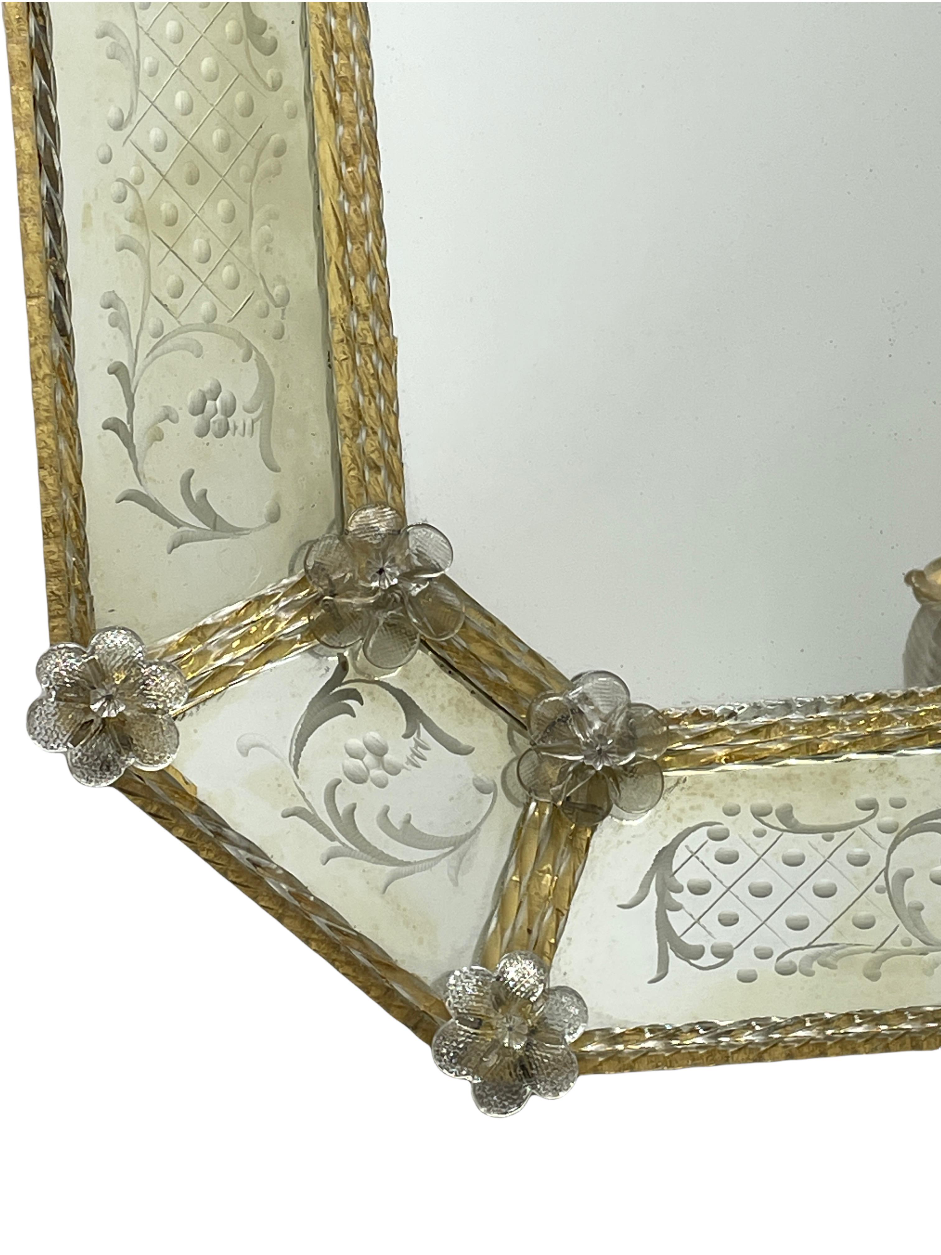 A stunning beautiful Murano glass mirror surrounded with handmade gold flake glass flowers. Age circa 1930s or older. With signs of wear as expected with age and use. The mirror fields at the edge are in distressed condition due to age, the inner