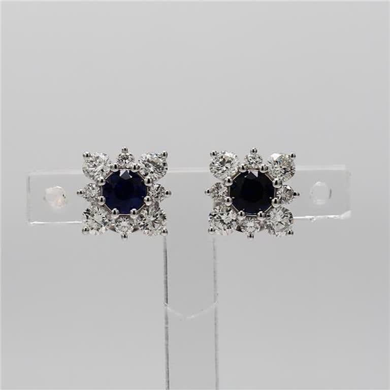 RareGemWorld's classic natural round cut sapphire earrings. Mounted in a beautiful 14K White Gold setting with natural round cut blue sapphires. The sapphires are surrounded by natural round white diamond melee in a beautiful flower shape. These