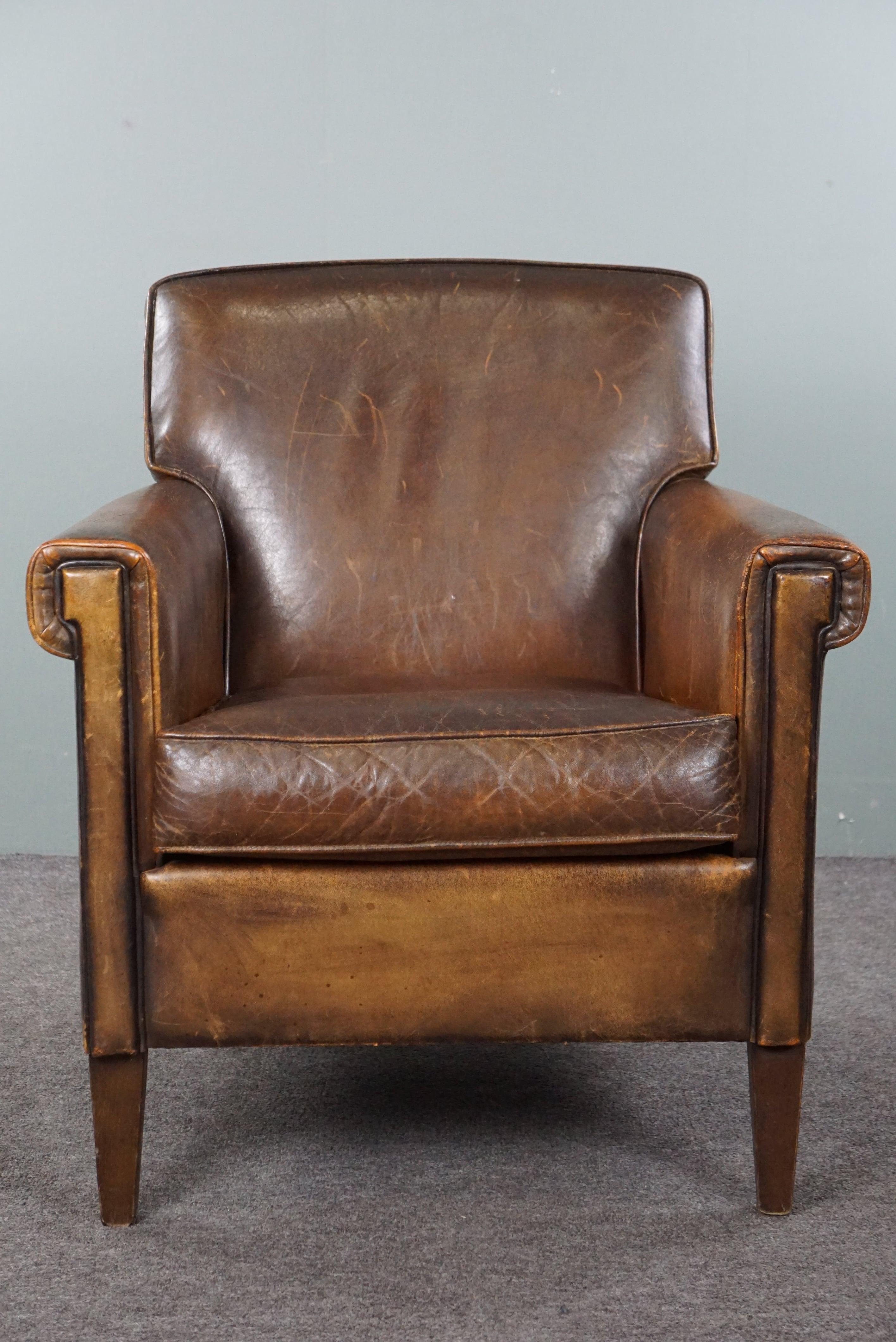 Angeboten wird dieser atemberaubende Sessel aus Schafsleder mit einer schönen Patina und charmanten Details. Wir freuen uns, Ihnen diesen Sessel präsentieren zu können. Es ist ein Modell, das man nicht oft sieht, und unserer Meinung nach ist es sehr