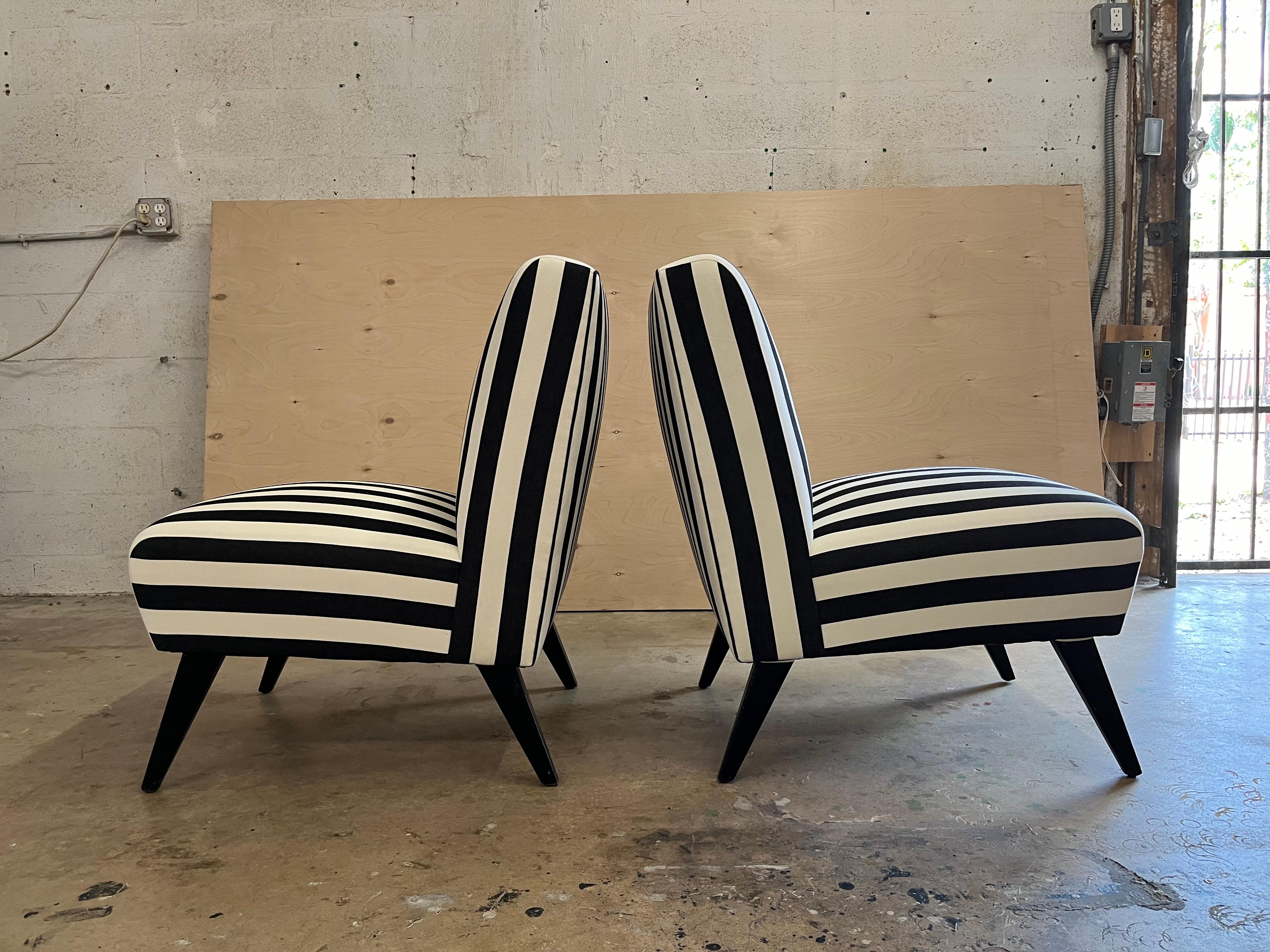 Paire de chaises longues des années 1950, pieds en bois noir et récemment retapissées en tissu de coton rayé noir et blanc. Les chaises sont dotées d'une sangle à ressorts d'origine. Prêt pour une nouvelle maison. 