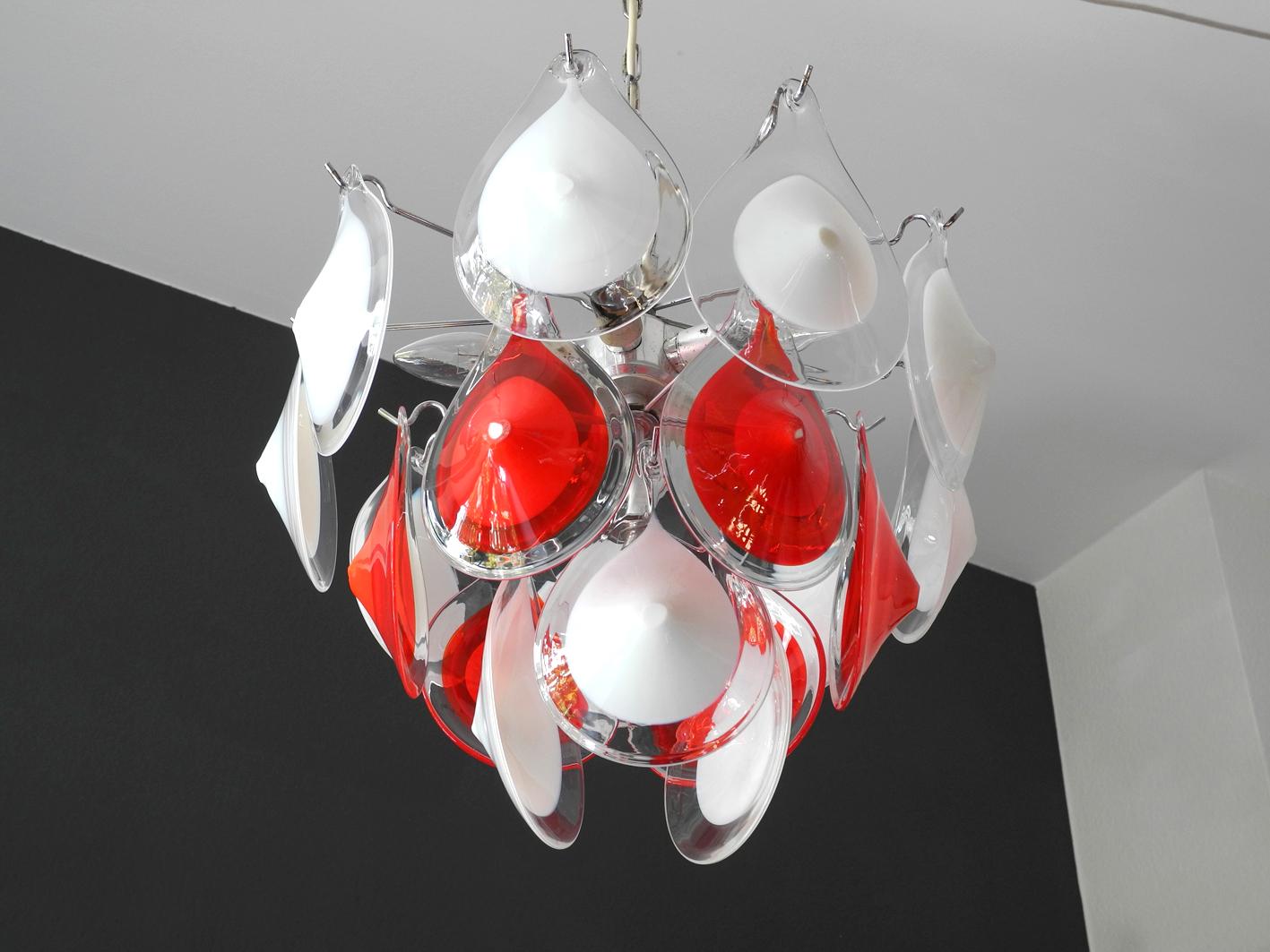 Beautiful original 1960s Vistosi Murano ceiling chandelier.
Design Gino Vistosi for Vetreria Vistosi. 18 red and white glasses, bulging drop shaped and outside transparent.
Very high quality lamp for a great charming lighting for any room.
Whole