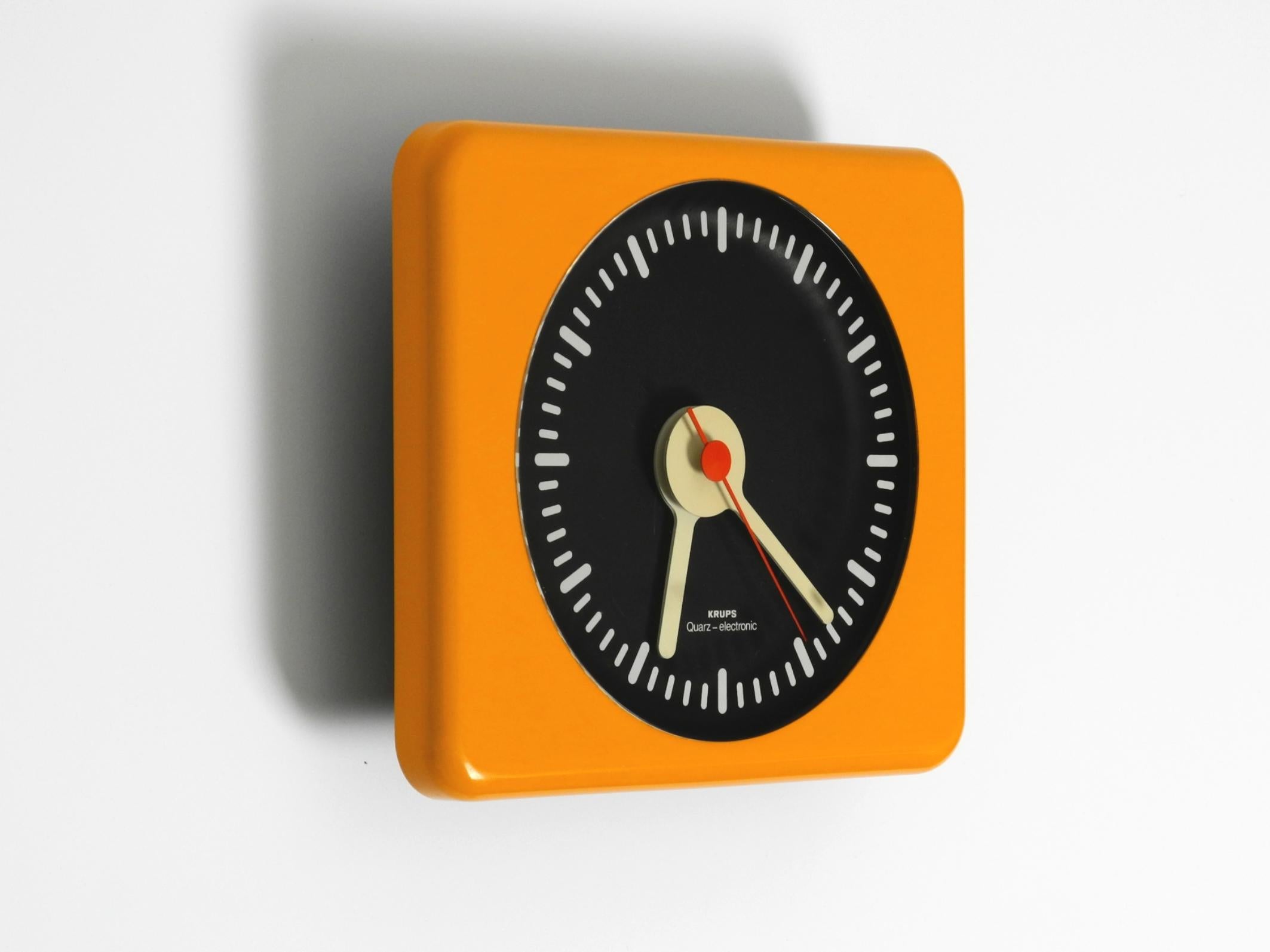 Beautiful 1970s original KRUPS wall clock in typical Space Age design. Made in Germany.
Case is made entirely of plastic. Front is in bright shiny orange, back in black.
No damage. No chips or scratches. Only slight signs of wear.
The color has not