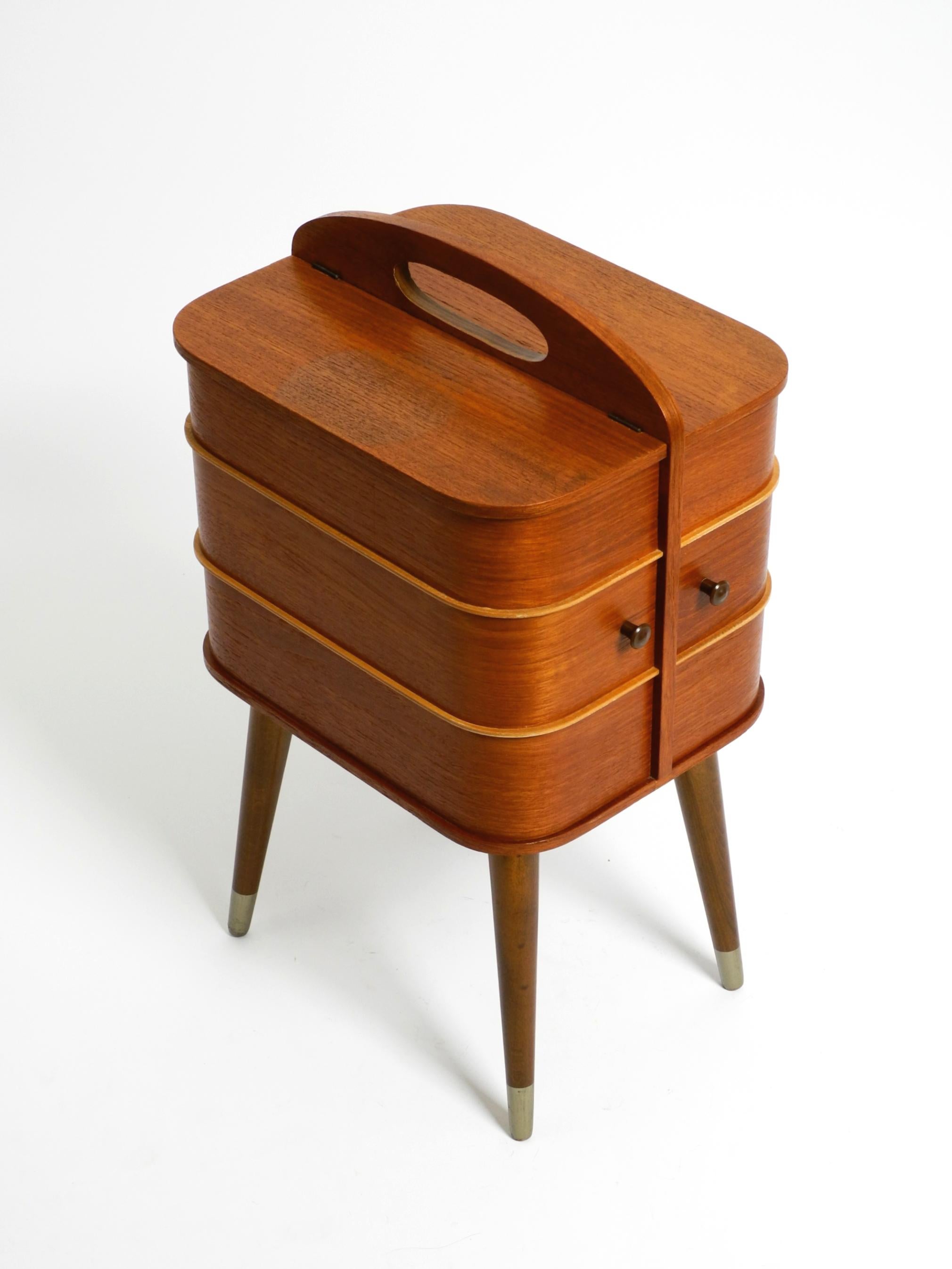 Original Mid Century Modern folding sewing box in a very good vintage condition.
Plywood with teak veneer.
Wonderfull beautiful 1950s design with lots of details and storage space.
Also very nice as a side table. Very clean and odorless.
Light signs