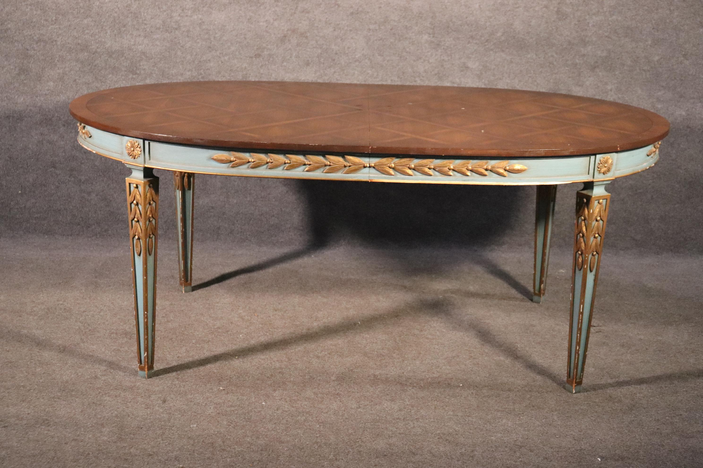 This is a beautiful blue and gold gilded dining table in the Directoire style with a gorgeous parquet top. The table features incredible lines and a gorgeous color scheme. The table is in good condition and dates to the 1950s era. The table measures