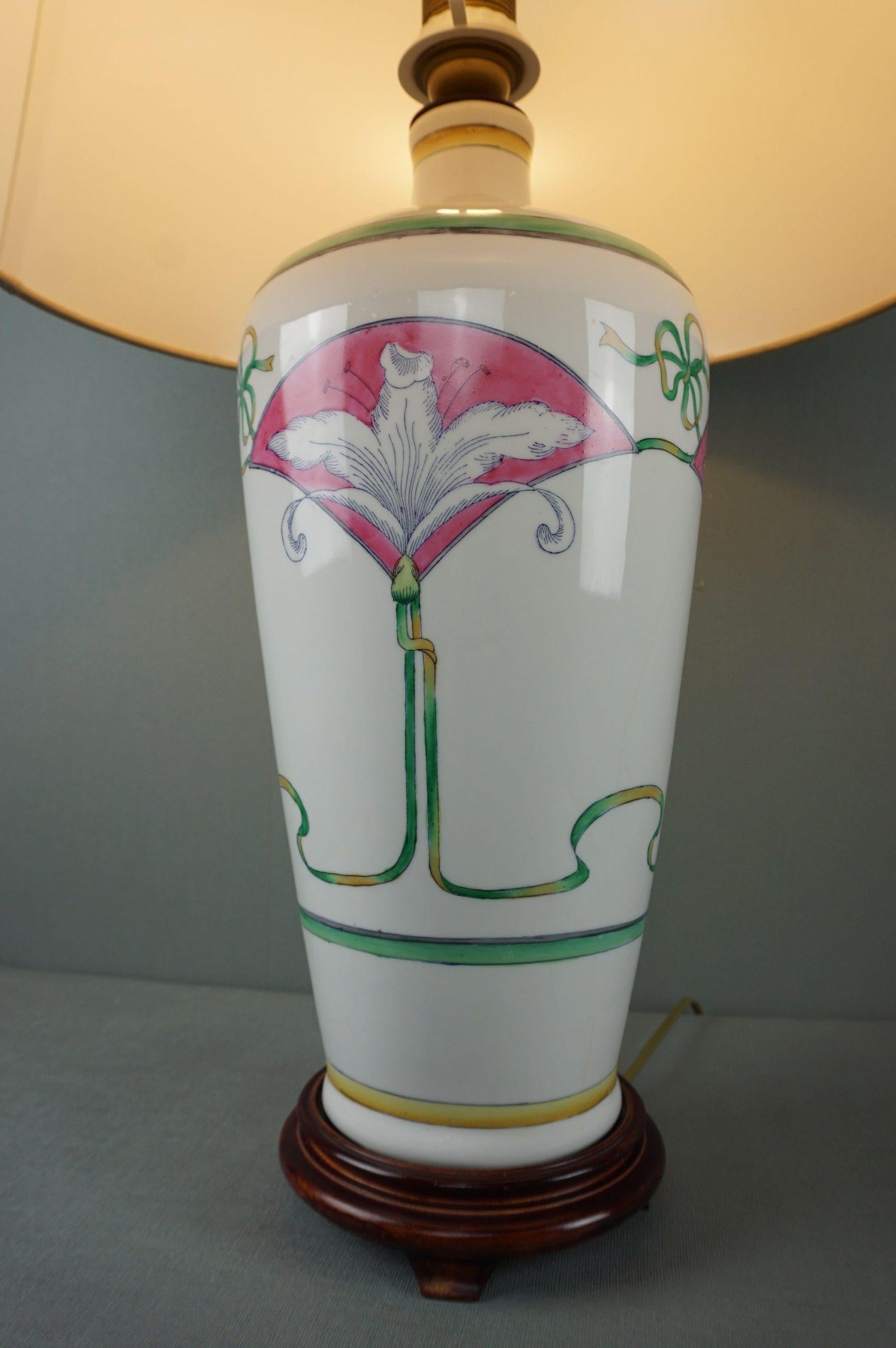 This beautiful painted table lamp has beautiful flower and leaf motifs.

This lamp with a lily pattern is a very attractive table lamp in a classic design. The combination of the white ceramic, the fabric shade and the wooden base make this lamp