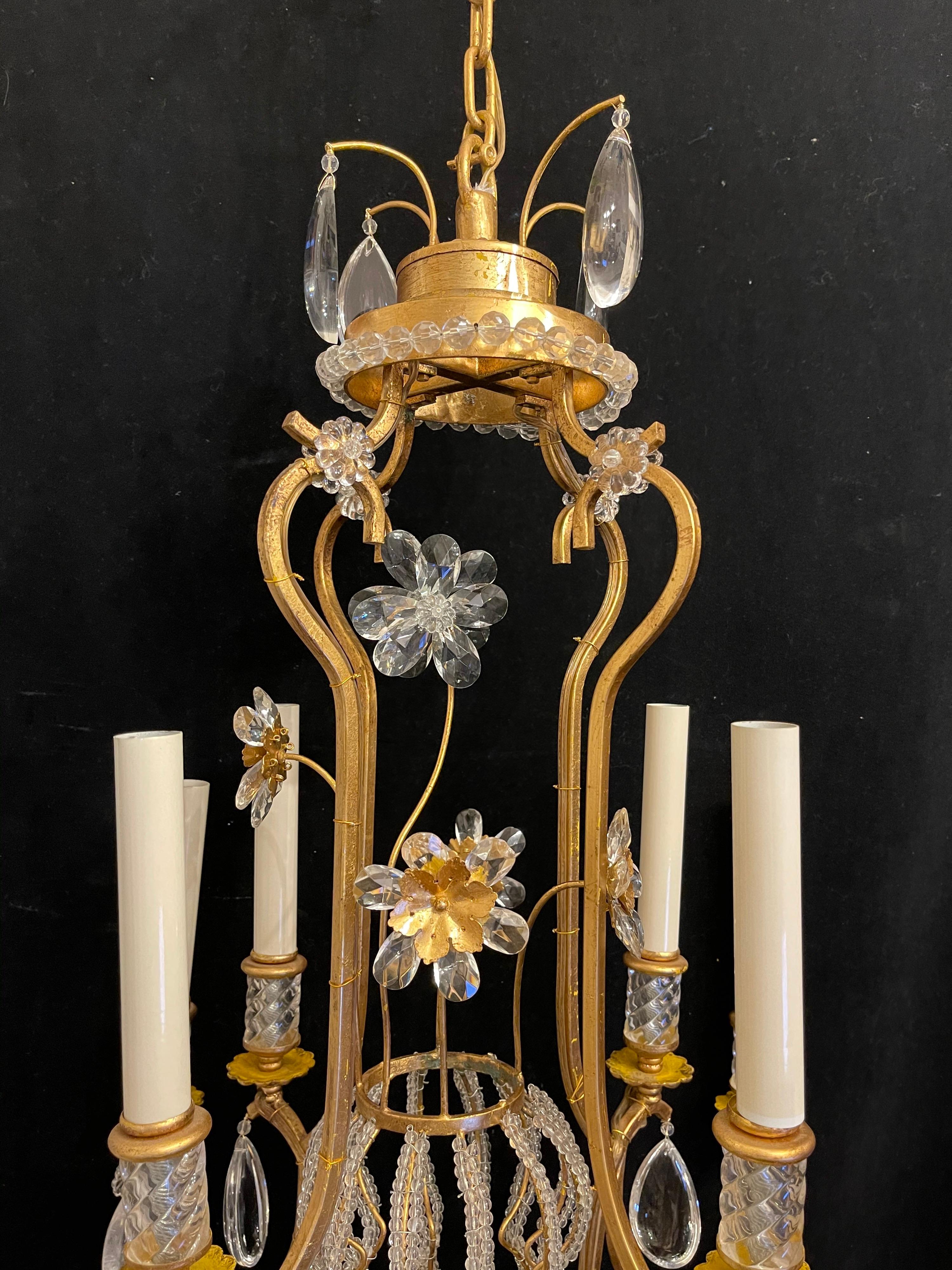 A beautiful pair of gold gilt Baguès / Jansen style rock crystal & beaded basket center chandeliers with 8 candelabra lights.