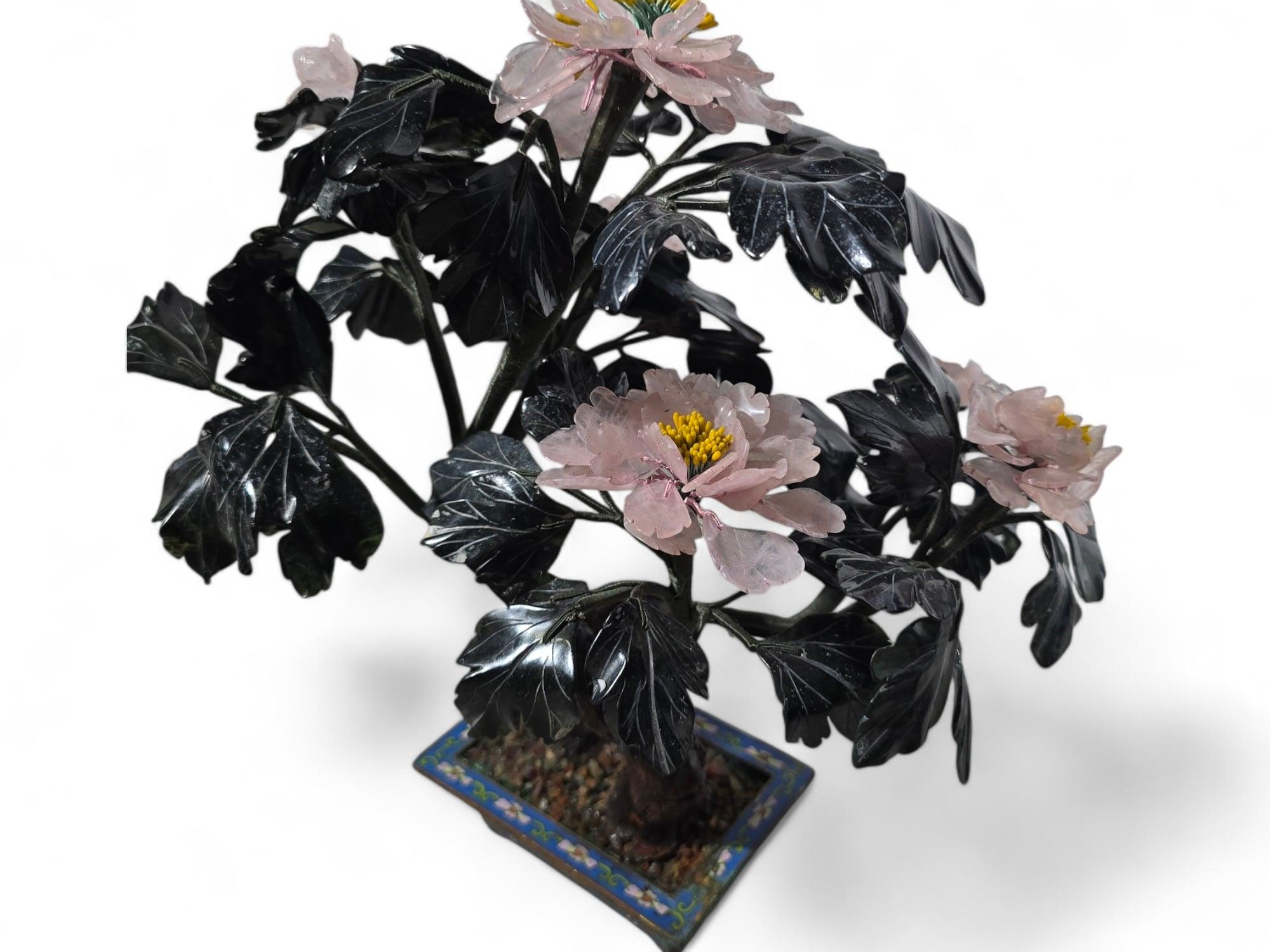 This exquisite pair of bonsai trees from the 20th century features vibrant, hand-crafted leaves and flowers made from agate, crystal, and nephrite jade. The trees are set in intricately designed cloisonné enamel copper flower pots, adding a touch of