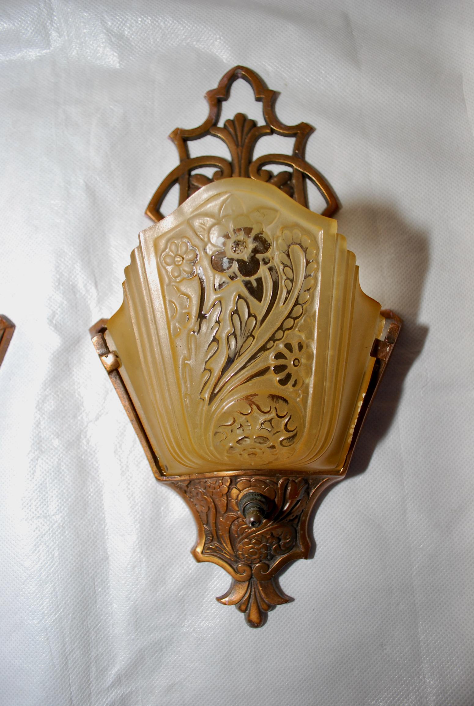 A beautiful pair of 1920's sconces, the frame is made of aluminum, with a broze color.