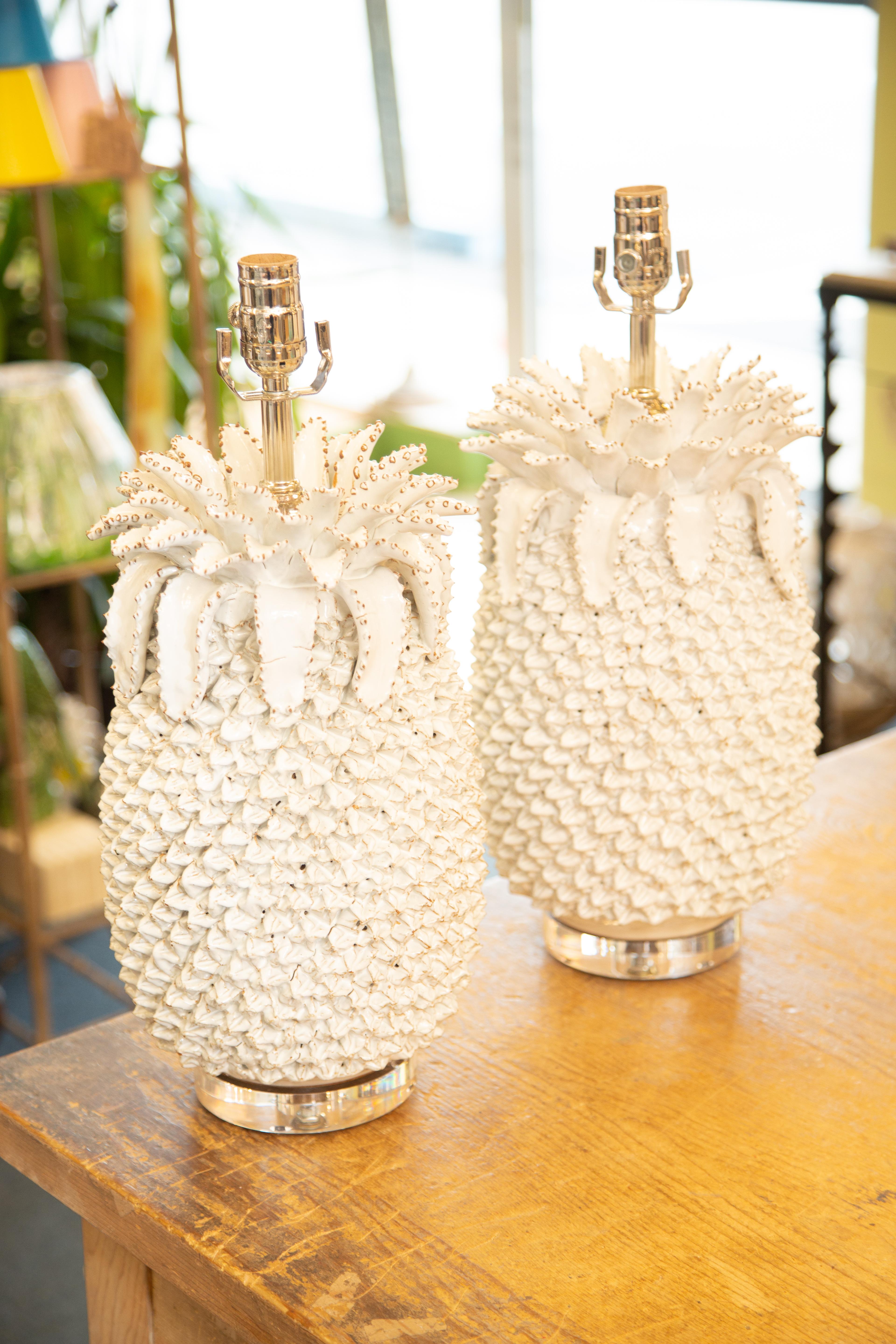 Beautiful pair of artful white porcelain prickly pineapple vases masterfully electrified into table lamps on custom round Lucite bases with new chrome 3-way socket and clear cord and price  is for the pair 