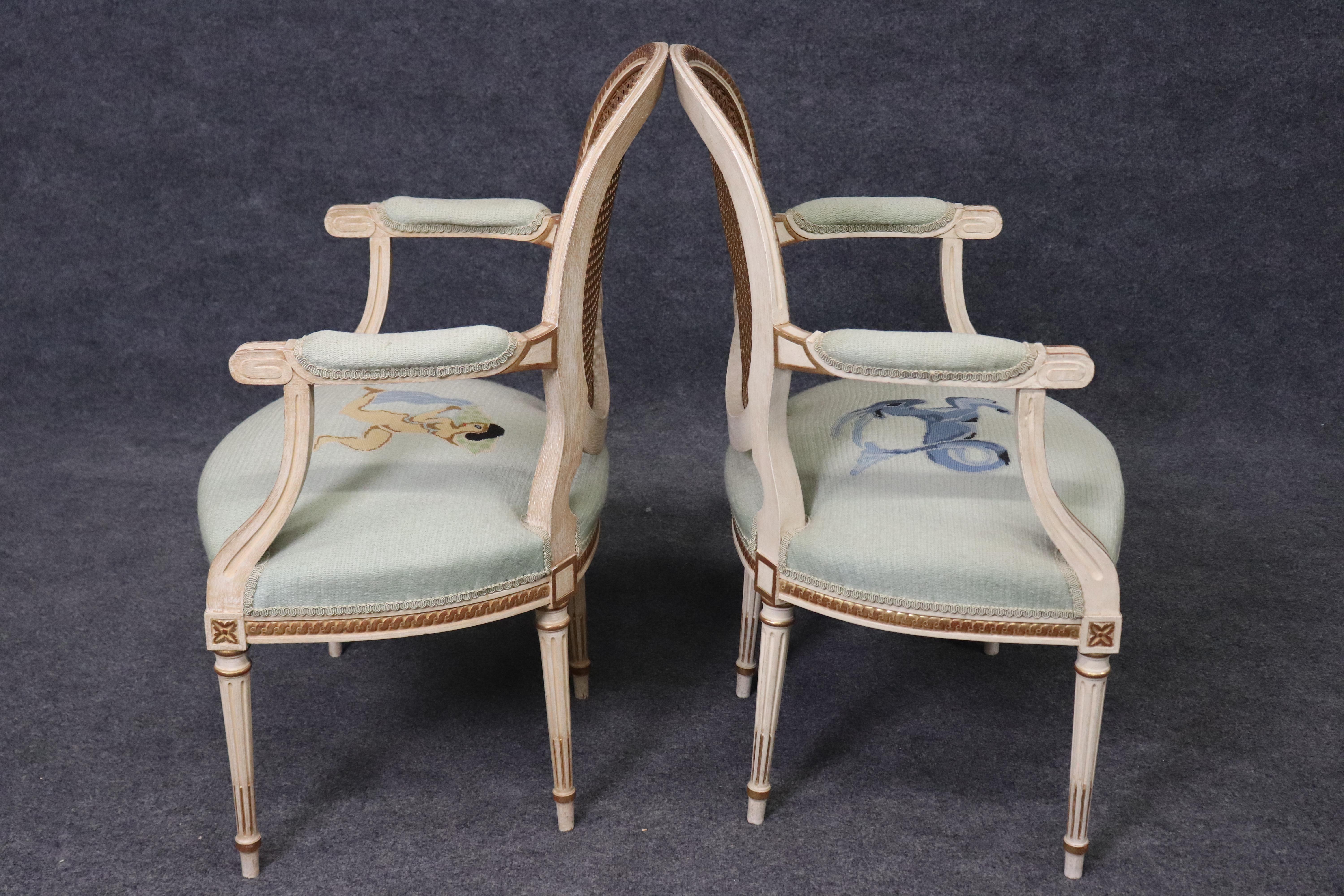 This is a Spanish-made pair of gorgeous French Louis XVI styled needlepoint upholstered cane back armchairs. They are whimsical and unique with their mermaid and Capricorn figures. The chairs are in good condition and have no significant condition