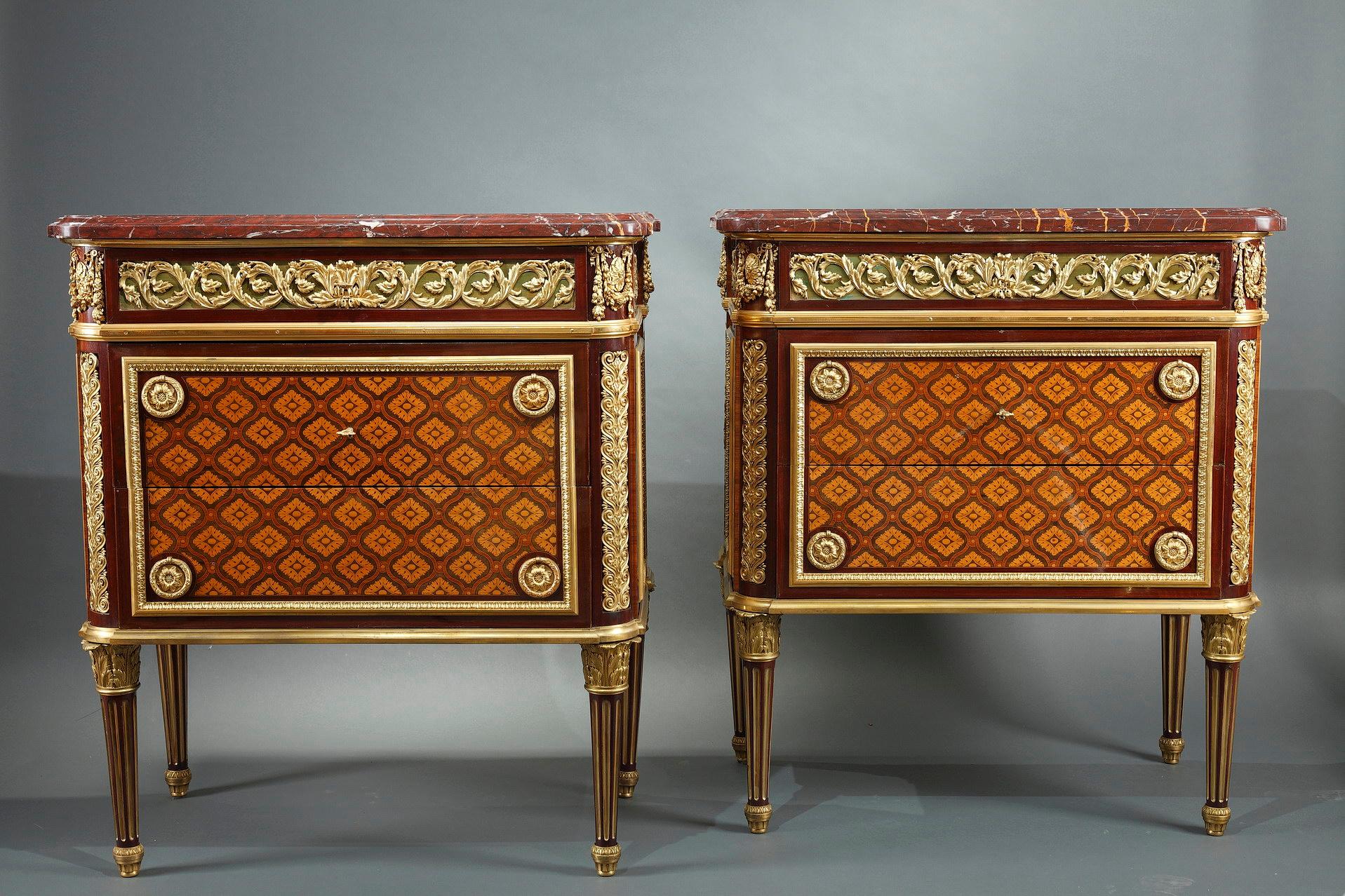 Pair of Louis XVI style commodes attributed to Krieger, in veneered wood and gilded bronze ; opening with three drawers, including one on the belt forming a writing desk and concealing two small side drawers. The commodes are decorated with an