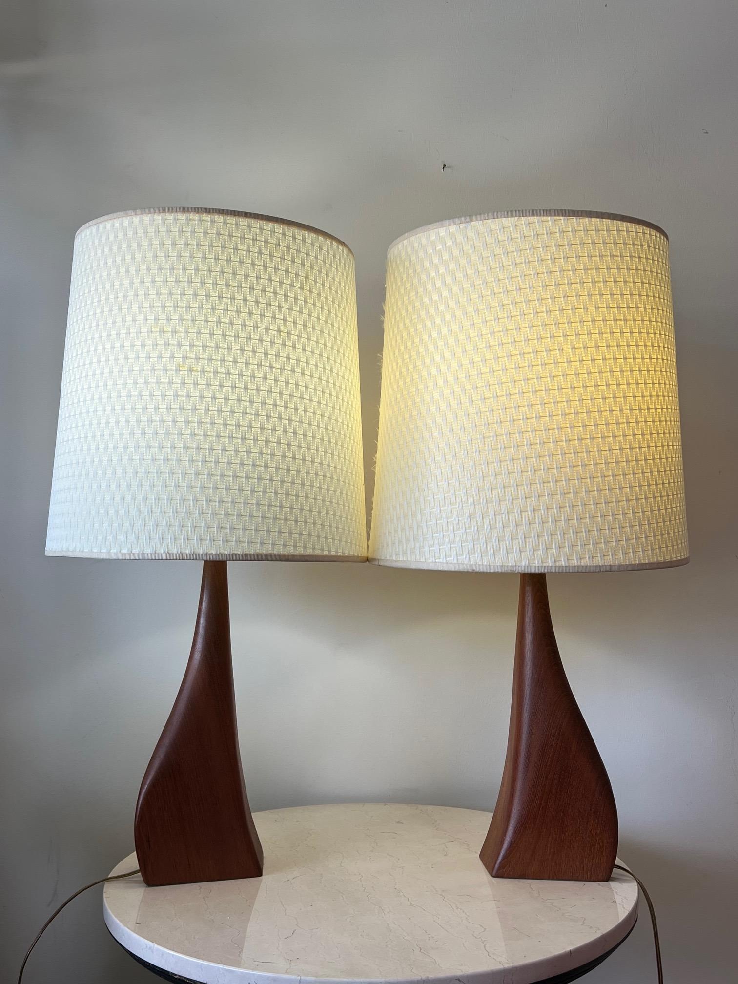 A pair of unusual, sculptural table lamps in teak designed by Johannes Aasbjerg and produced in Denmark for a short time in the early 1960s. The teak base is 16