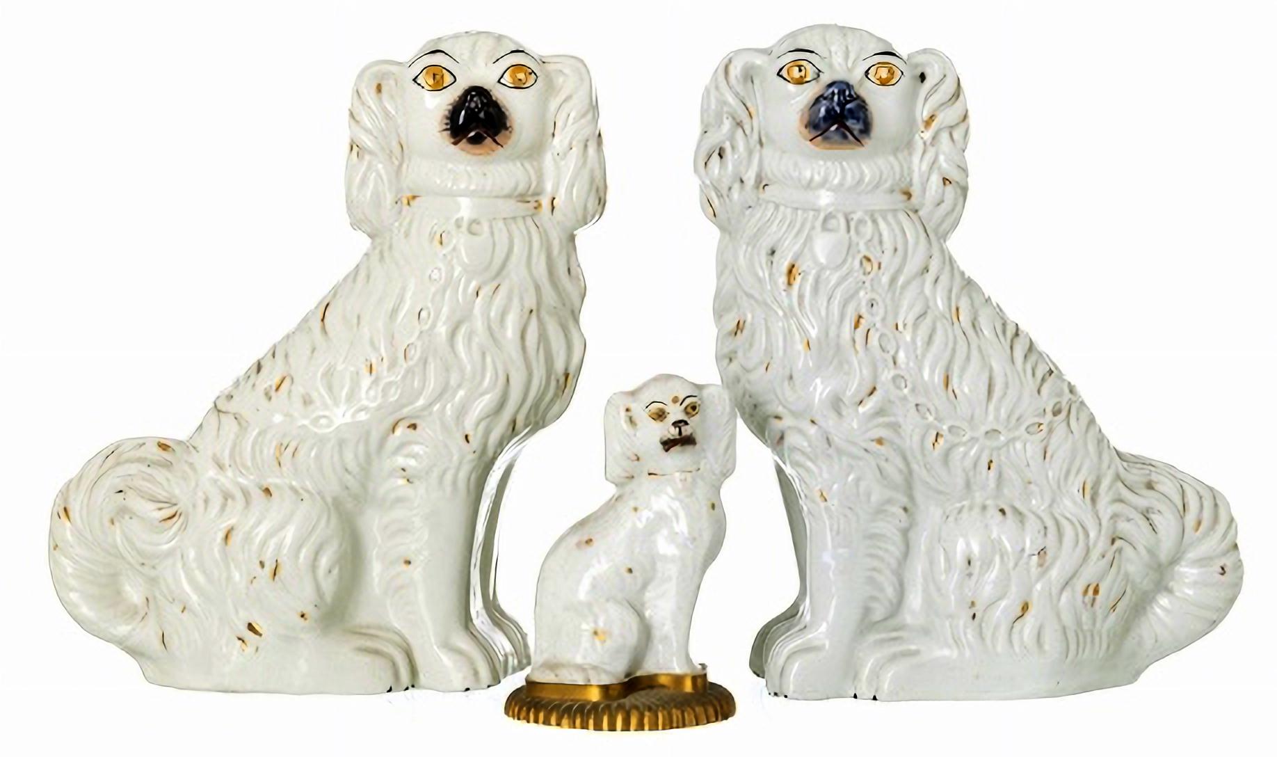 PAIR OF DOGS and an English DOG, 
19th century
in molded and embossed ceramic, one sitting on a gilded metal base. 
Small defects. 
Alt.: (largest) 30 cm.