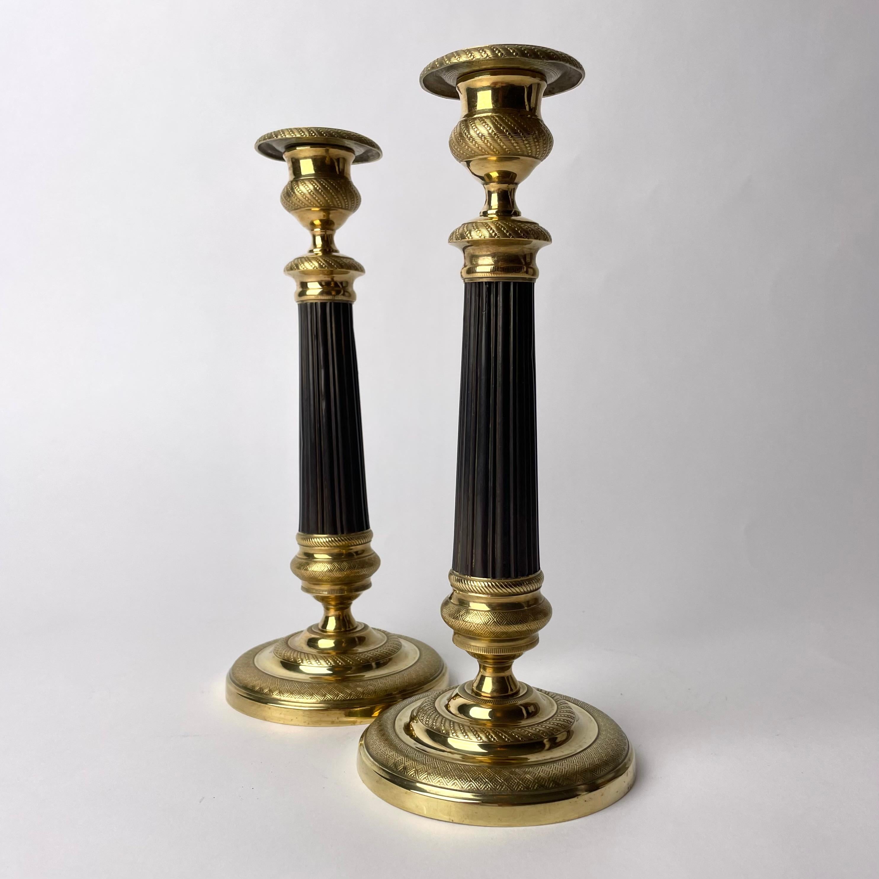 Wunderschönes Paar Empire-Kerzenleuchter aus vergoldeter und dunkel patinierter Bronze. Hergestellt in Frankreich in den 1820er Jahren. Sehr zeitgemäßes Design.

Abnutzung entsprechend dem Alter und dem Gebrauch 
