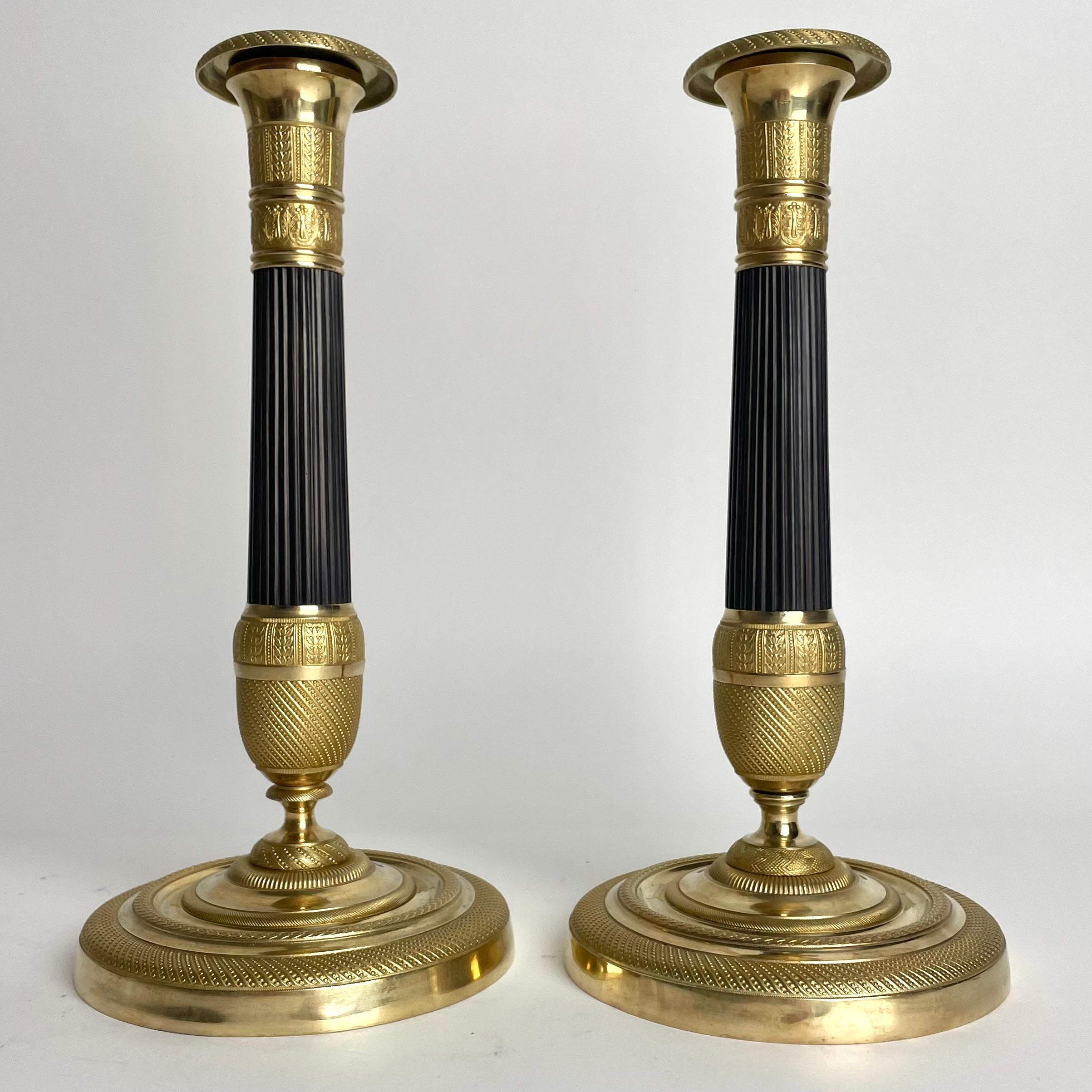 Preciosa pareja de candeleros Imperio en bronce dorado y patinado oscuro. 1820s Francés en venta