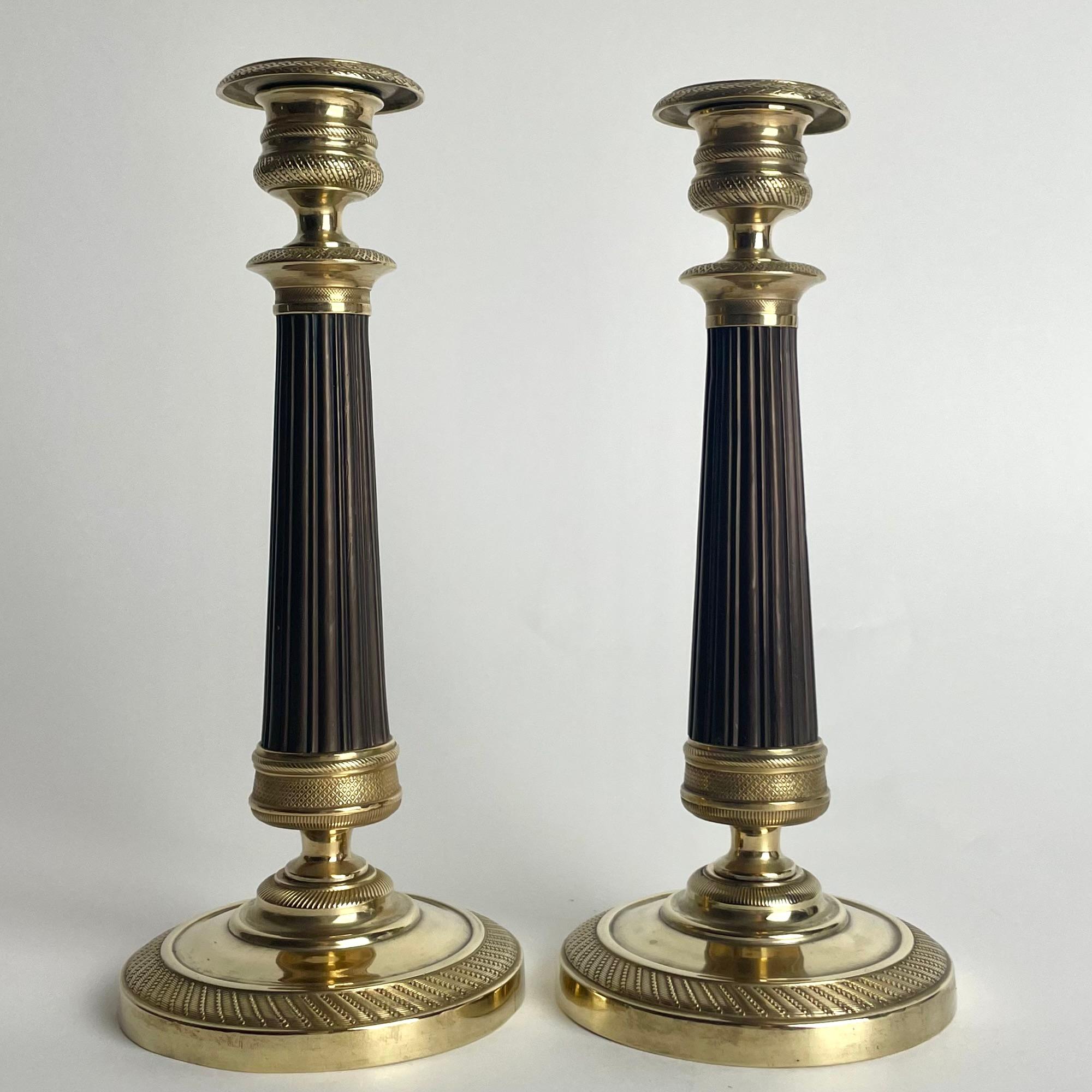 Preciosa pareja de candeleros Imperio en bronce dorado y patinado oscuro. 1820s Francés en venta