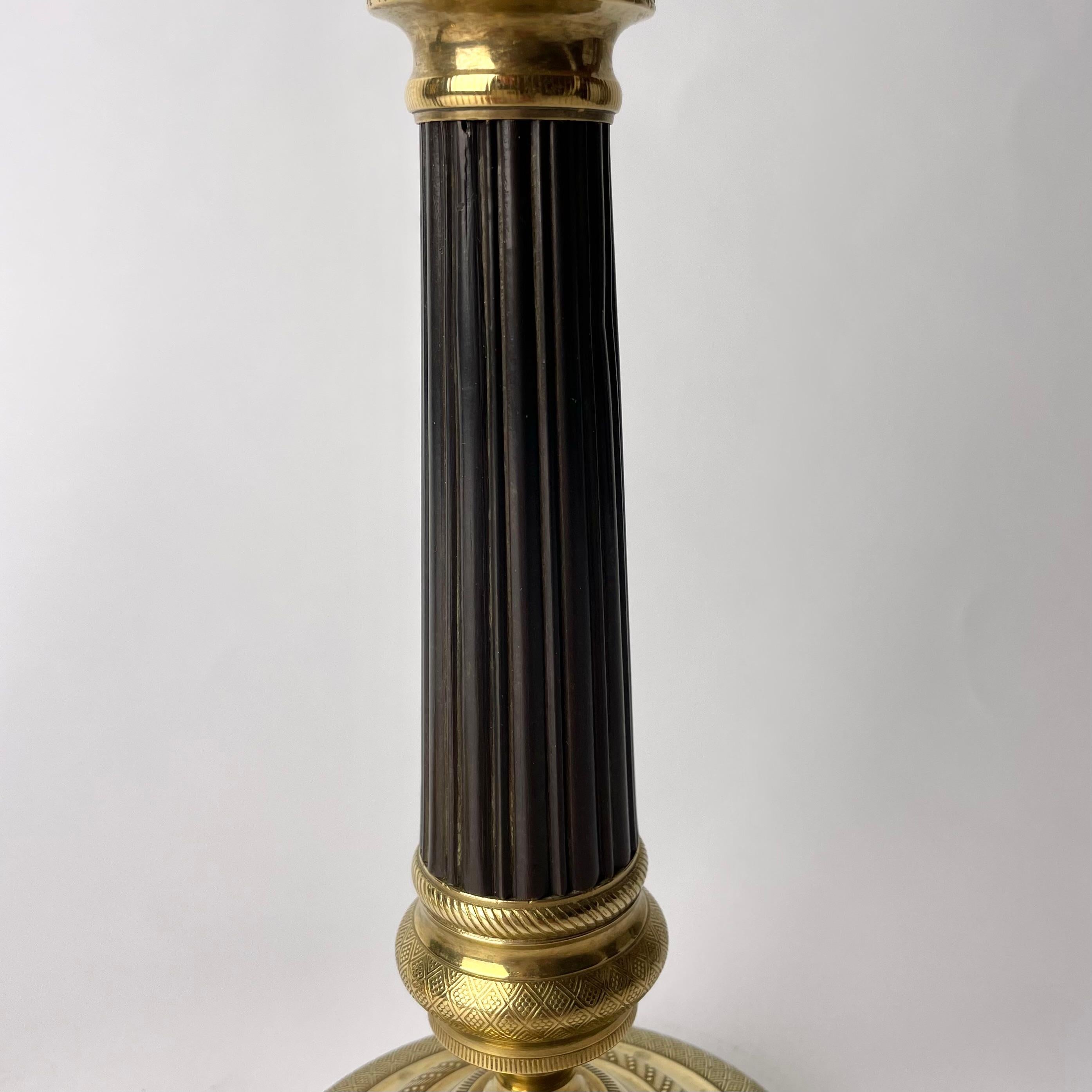 Early 19th Century Beautiful pair of Empire Candlesticks in gilt and dark patinated bronze. 1820s For Sale