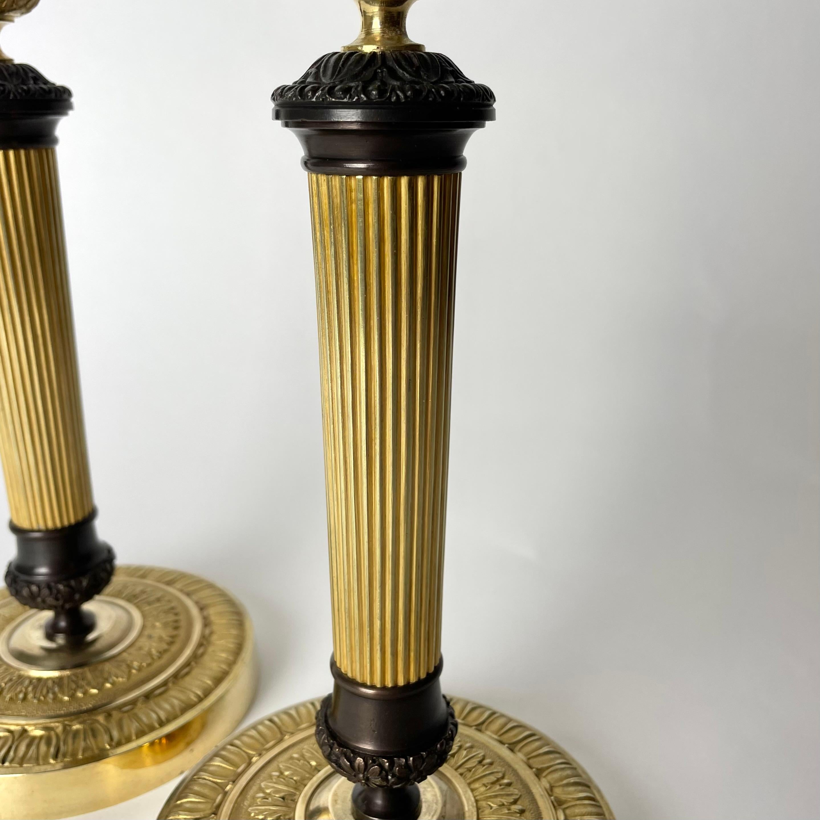 Schönes Paar Empire-Kerzenständer aus vergoldeter und dunkel patinierter Bronze. 1820er Jahre (Frühes 19. Jahrhundert) im Angebot