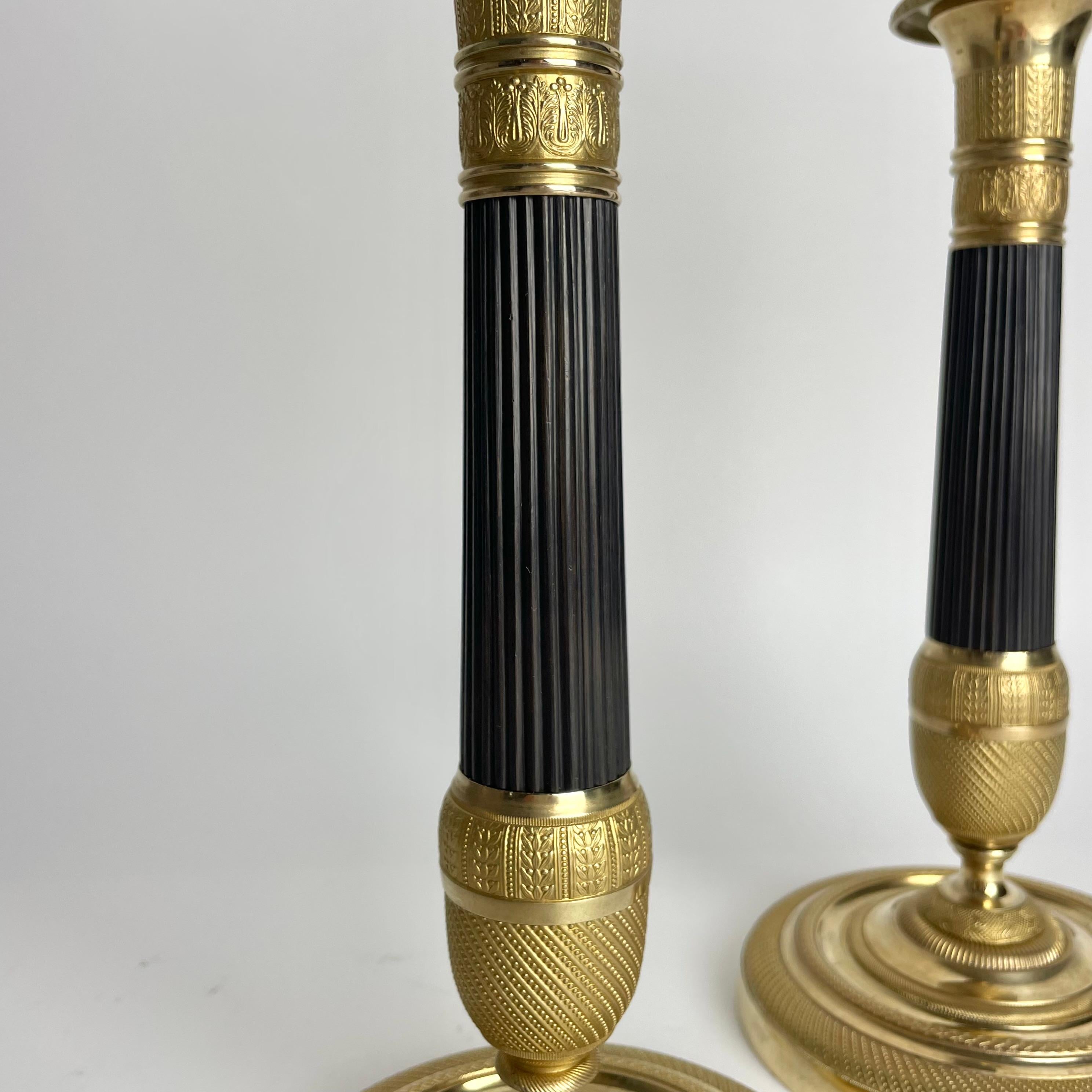 Preciosa pareja de candeleros Imperio en bronce dorado y patinado oscuro. 1820s principios del siglo XIX en venta