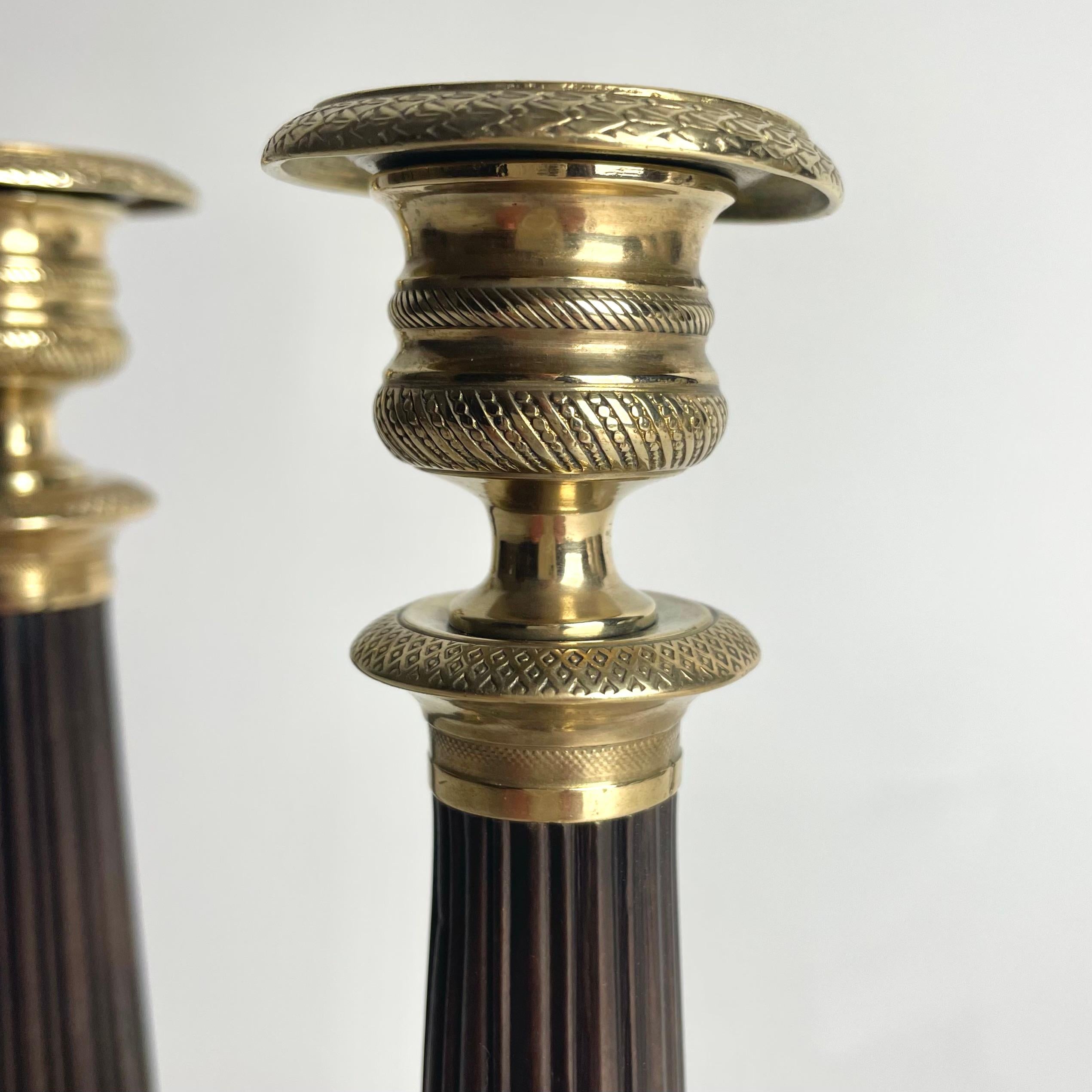 Preciosa pareja de candeleros Imperio en bronce dorado y patinado oscuro. 1820s principios del siglo XIX en venta