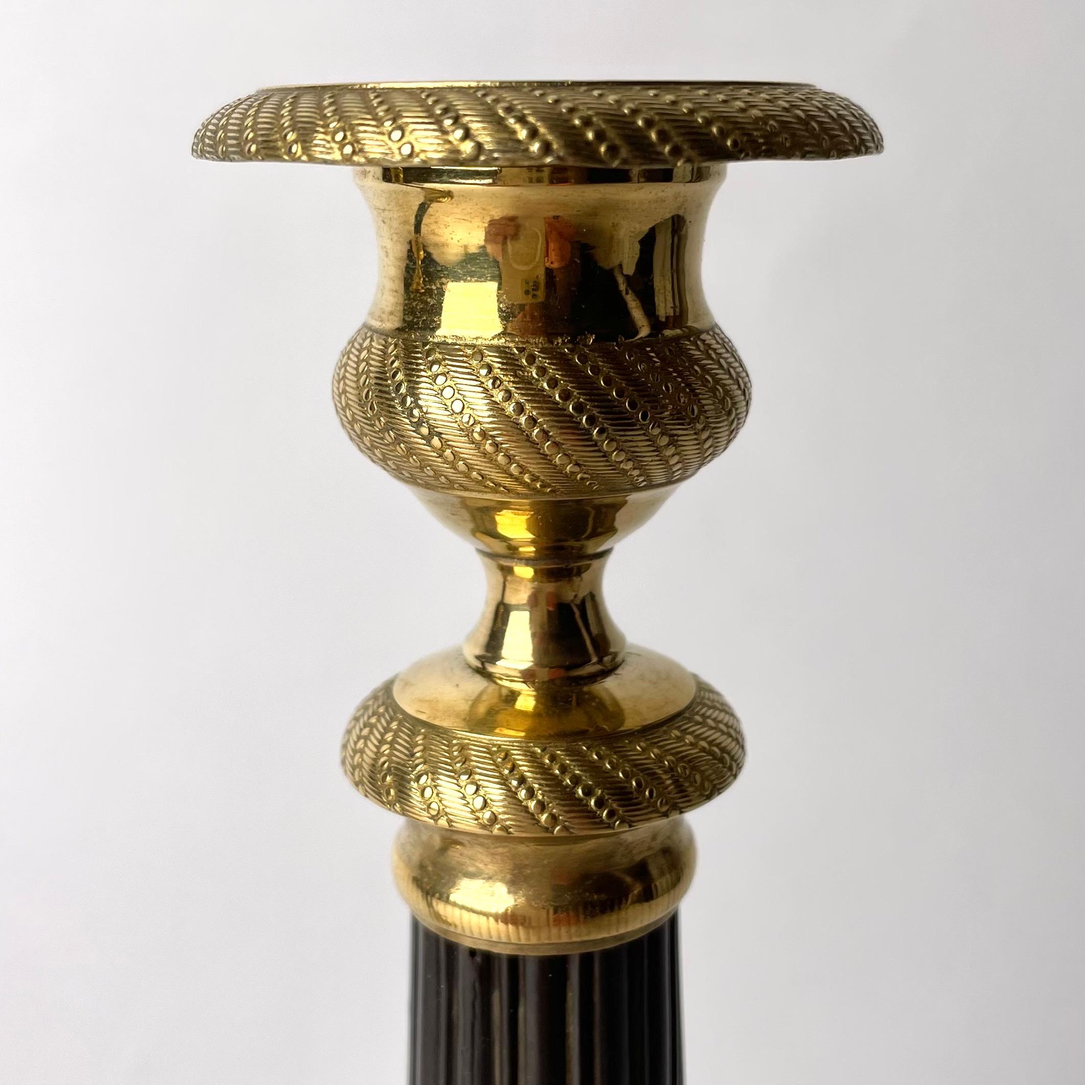 Bronze Beautiful pair of Empire Candlesticks in gilt and dark patinated bronze. 1820s For Sale