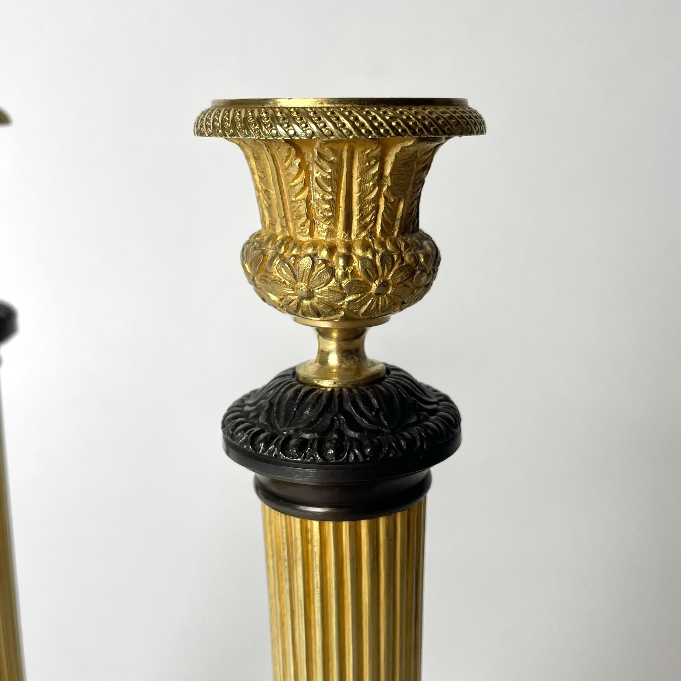 Schönes Paar Empire-Kerzenständer aus vergoldeter und dunkel patinierter Bronze. 1820er Jahre im Angebot 1
