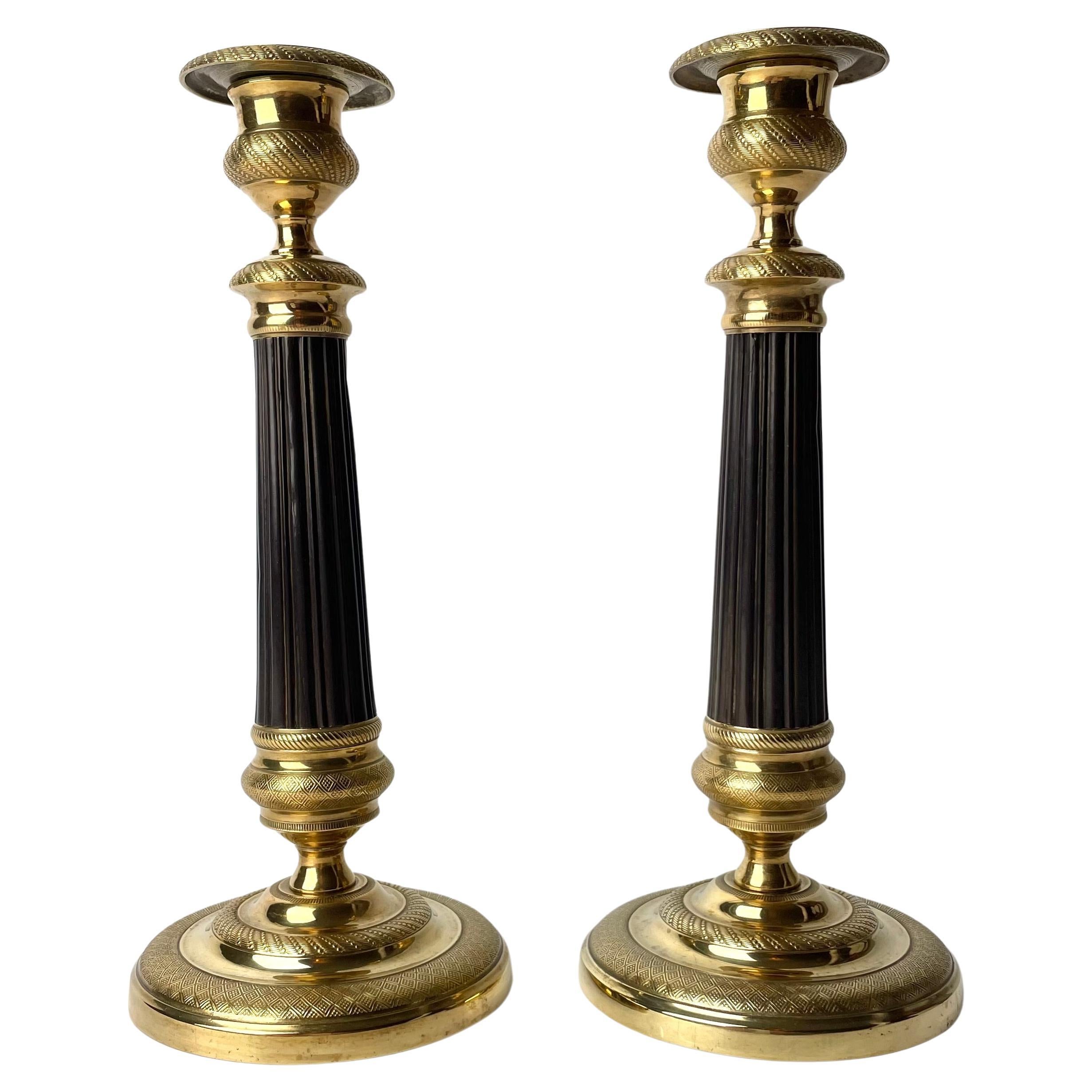 Beautiful pair of Empire Candlesticks in gilt and dark patinated bronze. 1820s