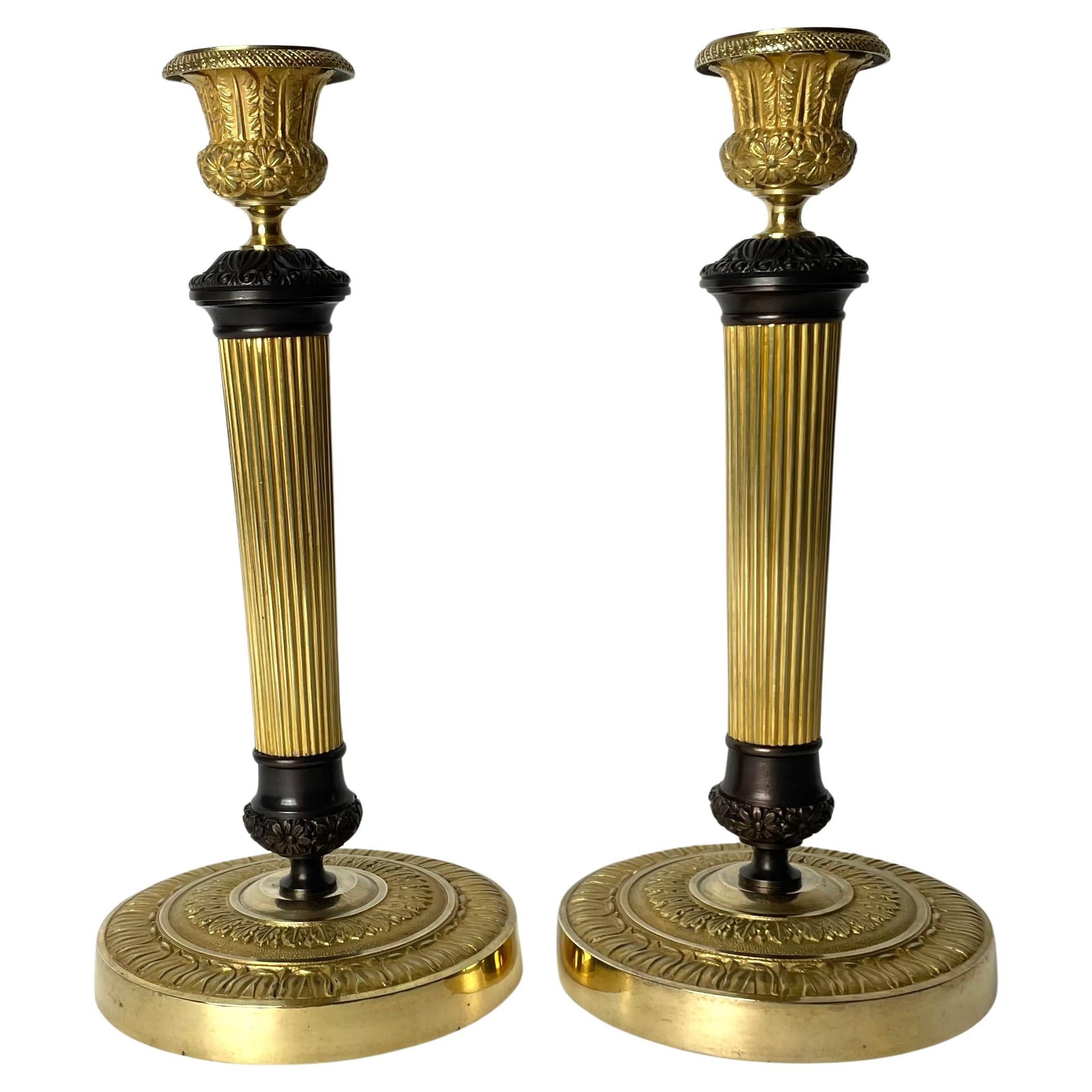 Beautiful pair of Empire Candlesticks in gilt and dark patinated bronze. 1820s For Sale