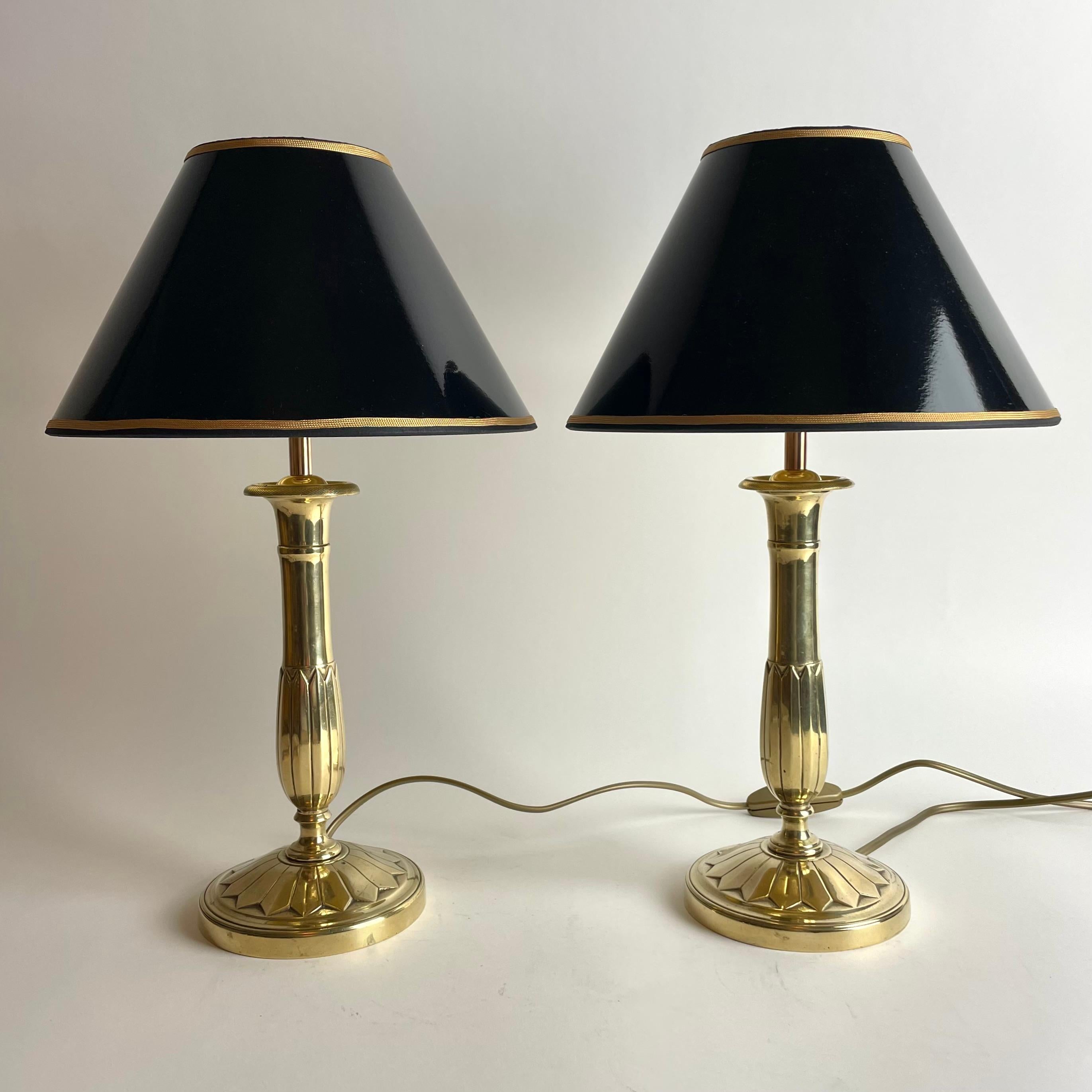 Beautiful pair of Empire Table Lamps in Bronze. Originally a pair of Empire candlesticks from the 1820s, converted to table lamps in the early 20th Century. 

Newly rewired electricity 

New lampshades in black lacquer with gilding on the inside,