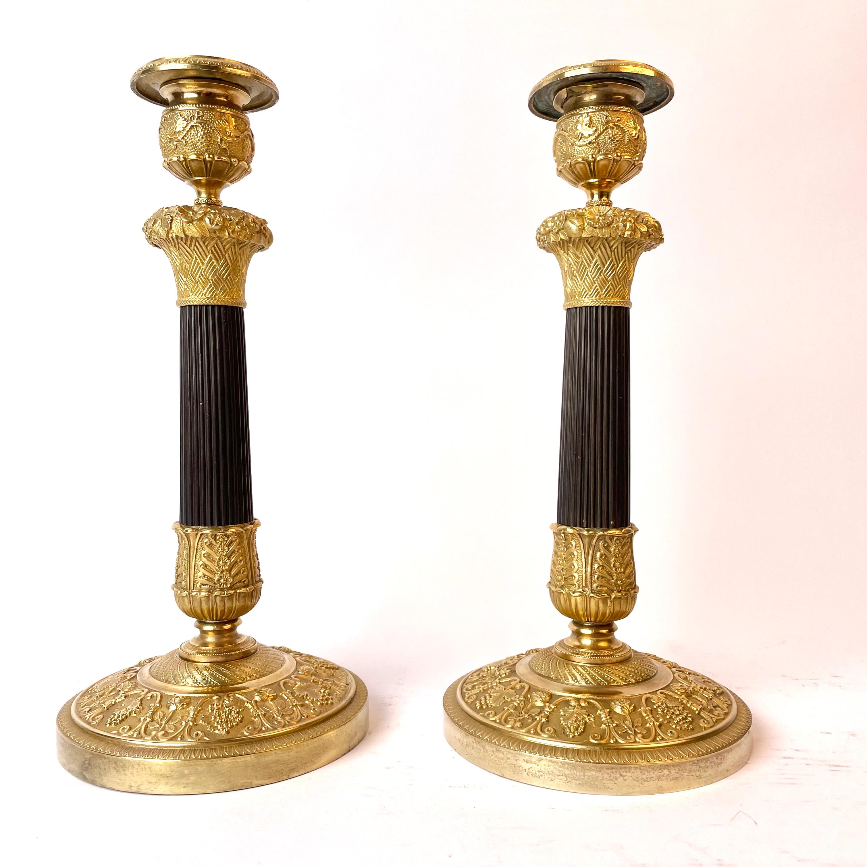 A beautiful pair of French Empire gilt and dark patinated bronze candlesticks from the 1820s. Decorated with flower baskets and bunches of grapes and a dark patinated column.


Wear consistent with age and use.