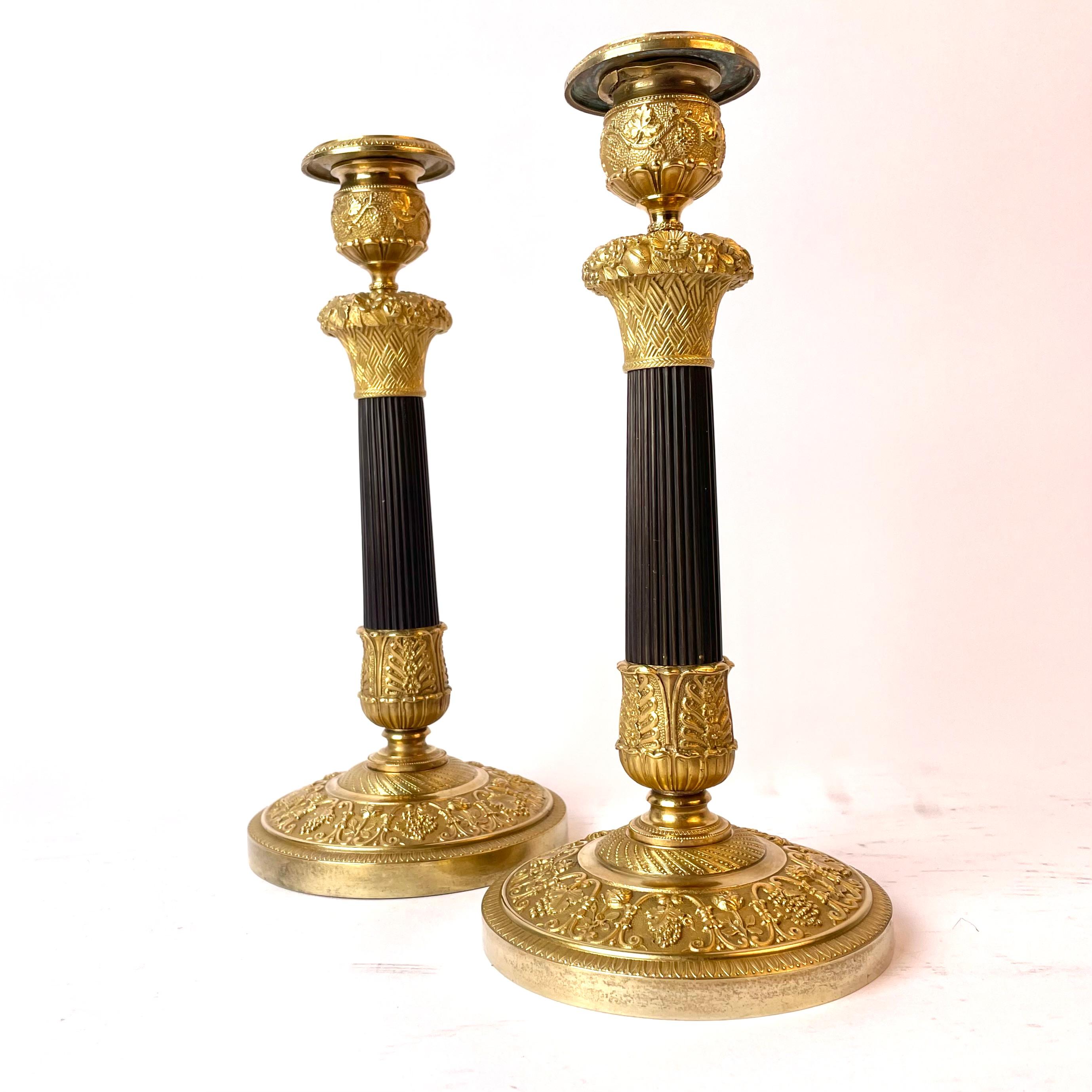 Schönes Paar französischer Empire-Kerzenständer aus vergoldeter und dunkel patinierter Bronze (Französisch) im Angebot