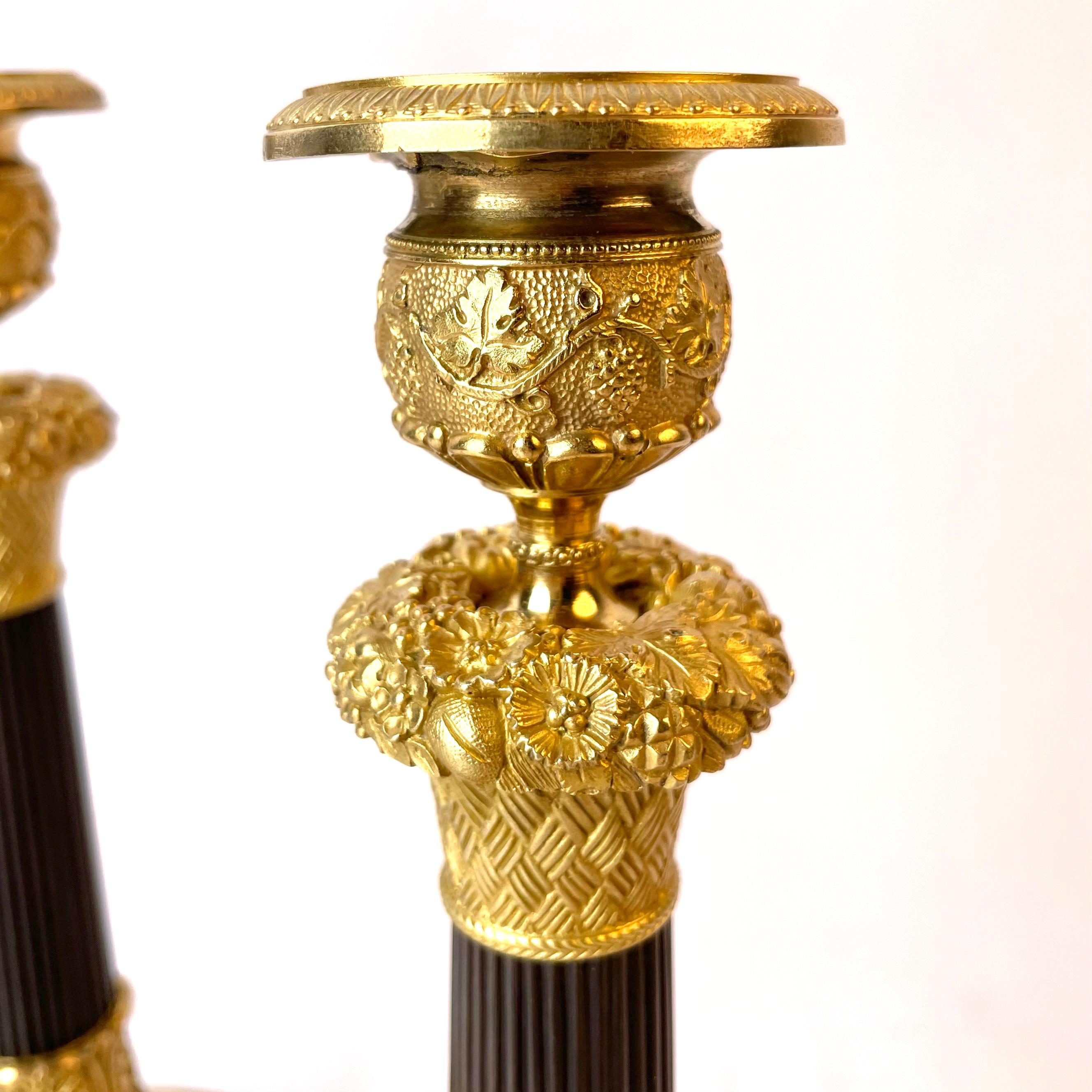 Schönes Paar französischer Empire-Kerzenständer aus vergoldeter und dunkel patinierter Bronze (Vergoldung) im Angebot