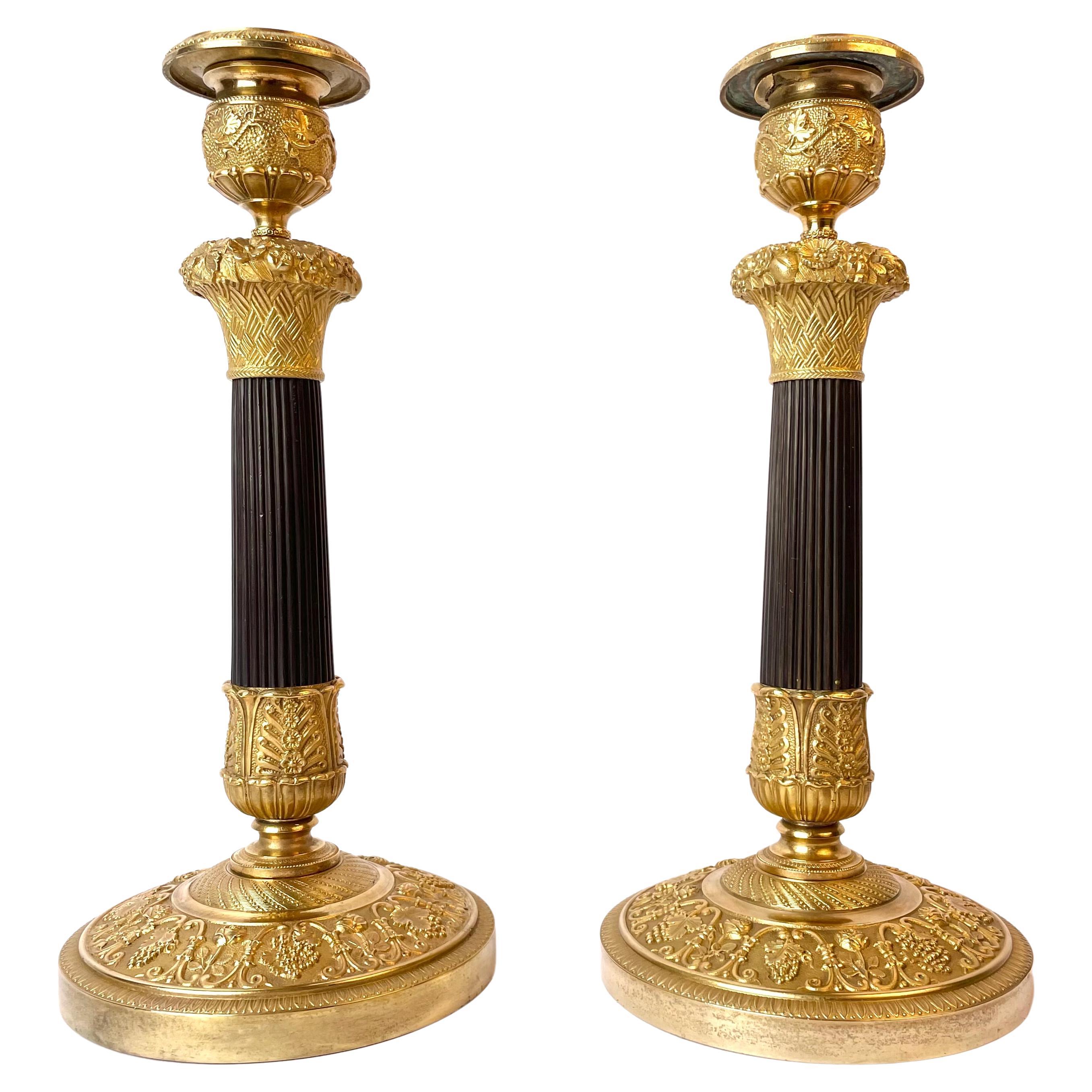 Magnifique paire de chandeliers Empire français en bronze doré et patiné foncé